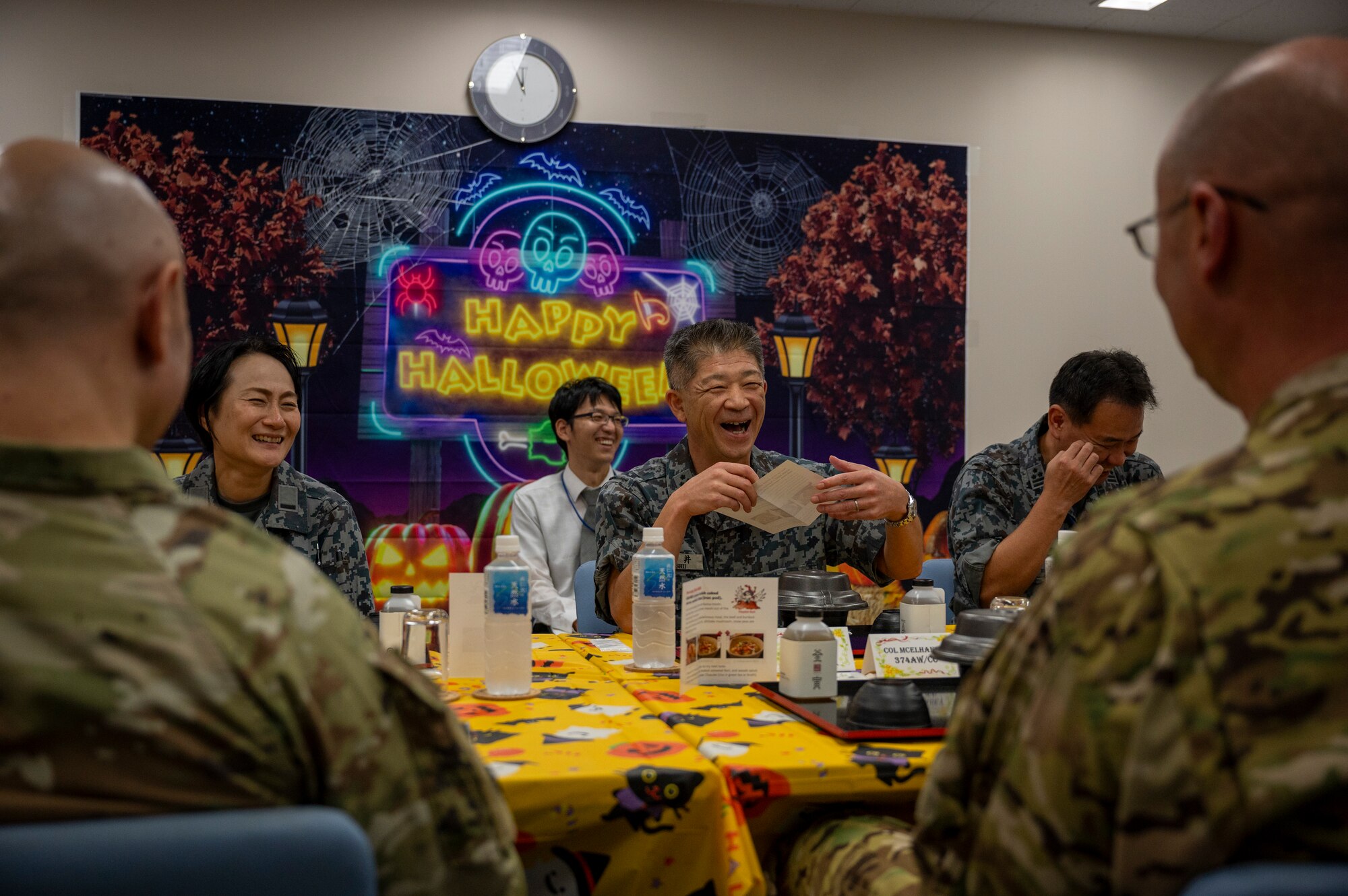 Japan military members laugh during a lunch.