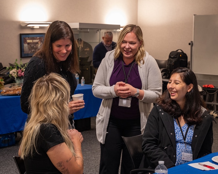 Key Support Liaisons chat during a small break while attending the Key Support Liaison Symposium at Royal Air Force Mildenhall, England, Oct. 1, 2024.