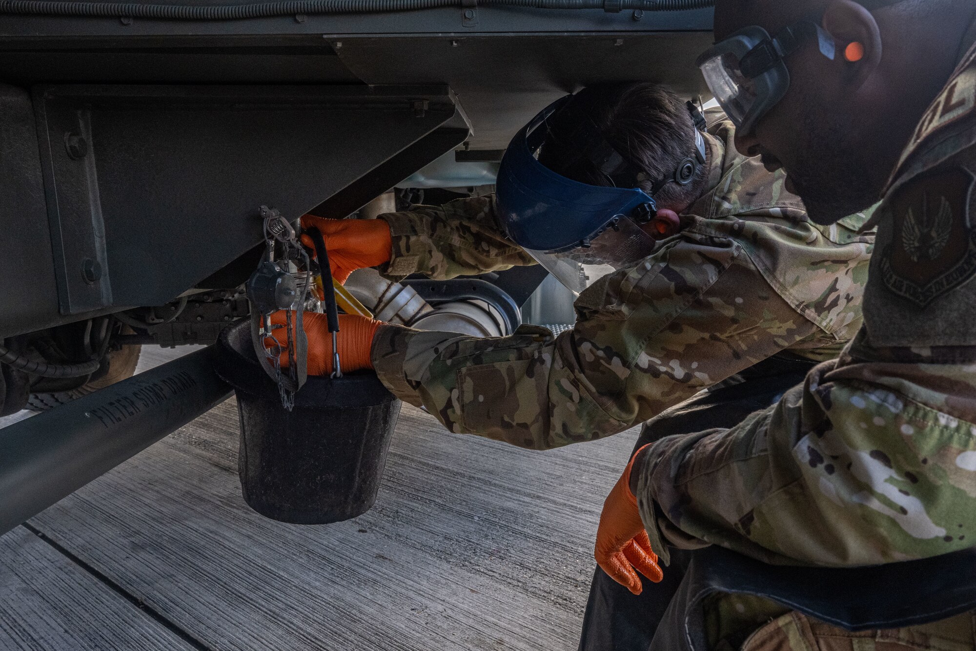 U.S. Air Force Senior Airman Jovon Green, right, 100th Logistics Readiness Squadron fuels facility technician, watches as Col. Joseph Wall, 100th Air Refueling Wing deputy commander, drains the excess water from the mobile refueling truck at Royal Air Force Mildenhall, England, Oct. 4, 2024.