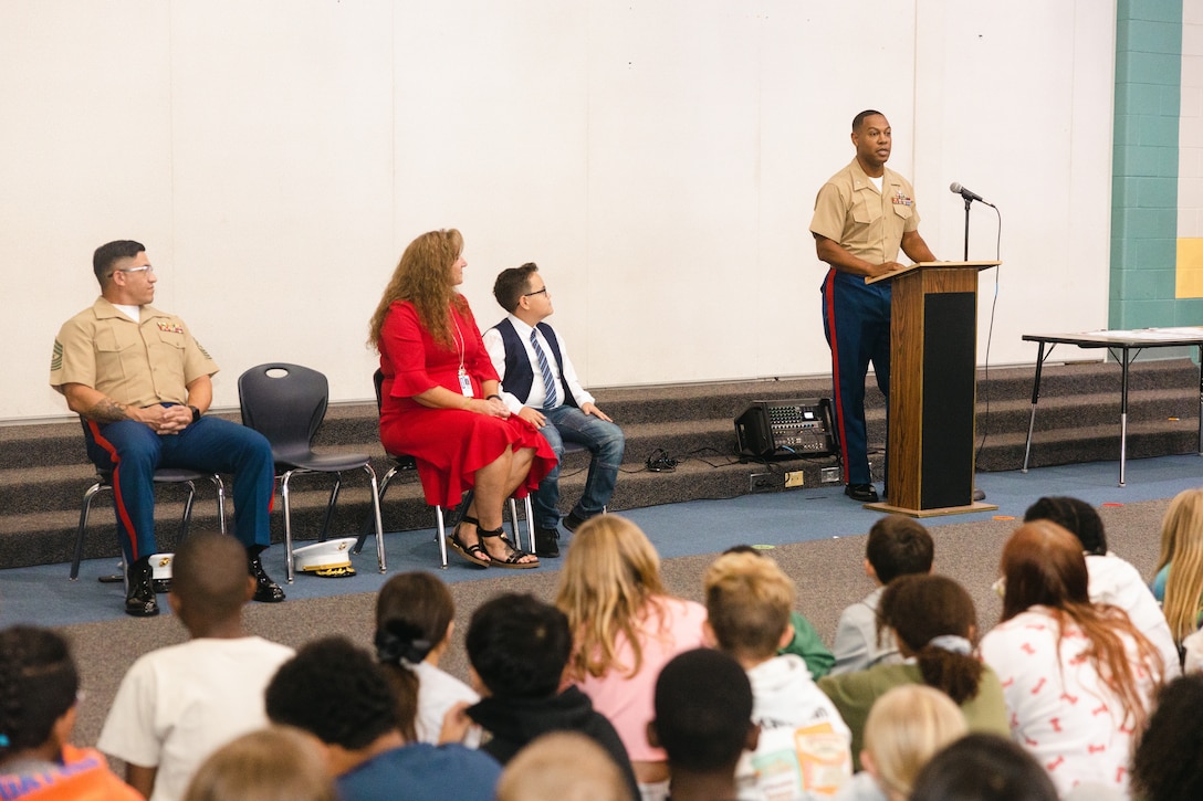 U.S. Marine Corps Lt. Col. Anthony M. Ansley II, right, commanding officer, Combat Logistics Battalion 22, Combat Logistics Regiment 2, 2nd Marine Logistics Group, speaks to students during a CLB-22 adopt-a-school event at Carolina Forest International Elementary School in Jacksonville, North Carolina, Oct. 2, 2024. CLB-22 signed a Proclamation of Adoption Partnership with Carolina Forest International Elementary School to strengthen the relationship between Marines and the students through volunteering and mentorship. (U.S. Marine Corps photo by Sgt. Mary Kohlmann)