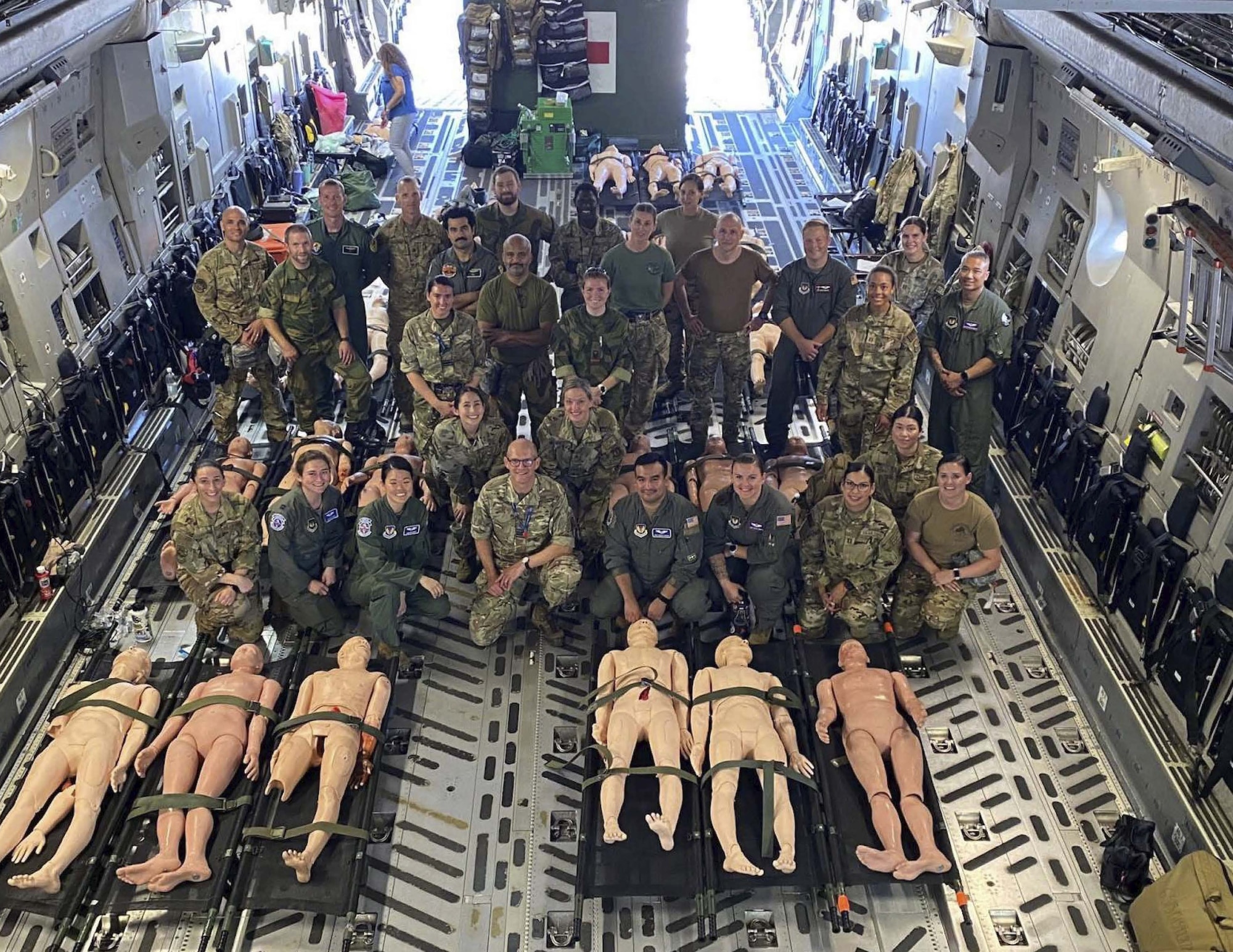 A group photo is taken in the back of an aircraft during an exercise.