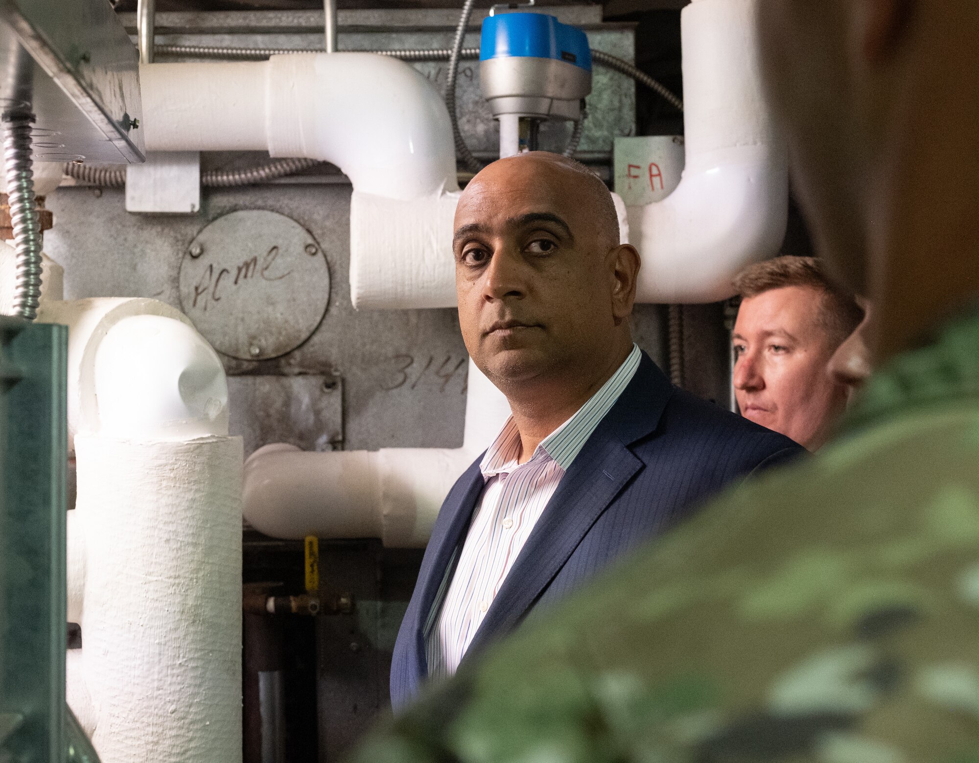Dr. Ravi Chaudhary is being explained the condition of the heating, ventilation, and air conditioning while standing next to the equipment.