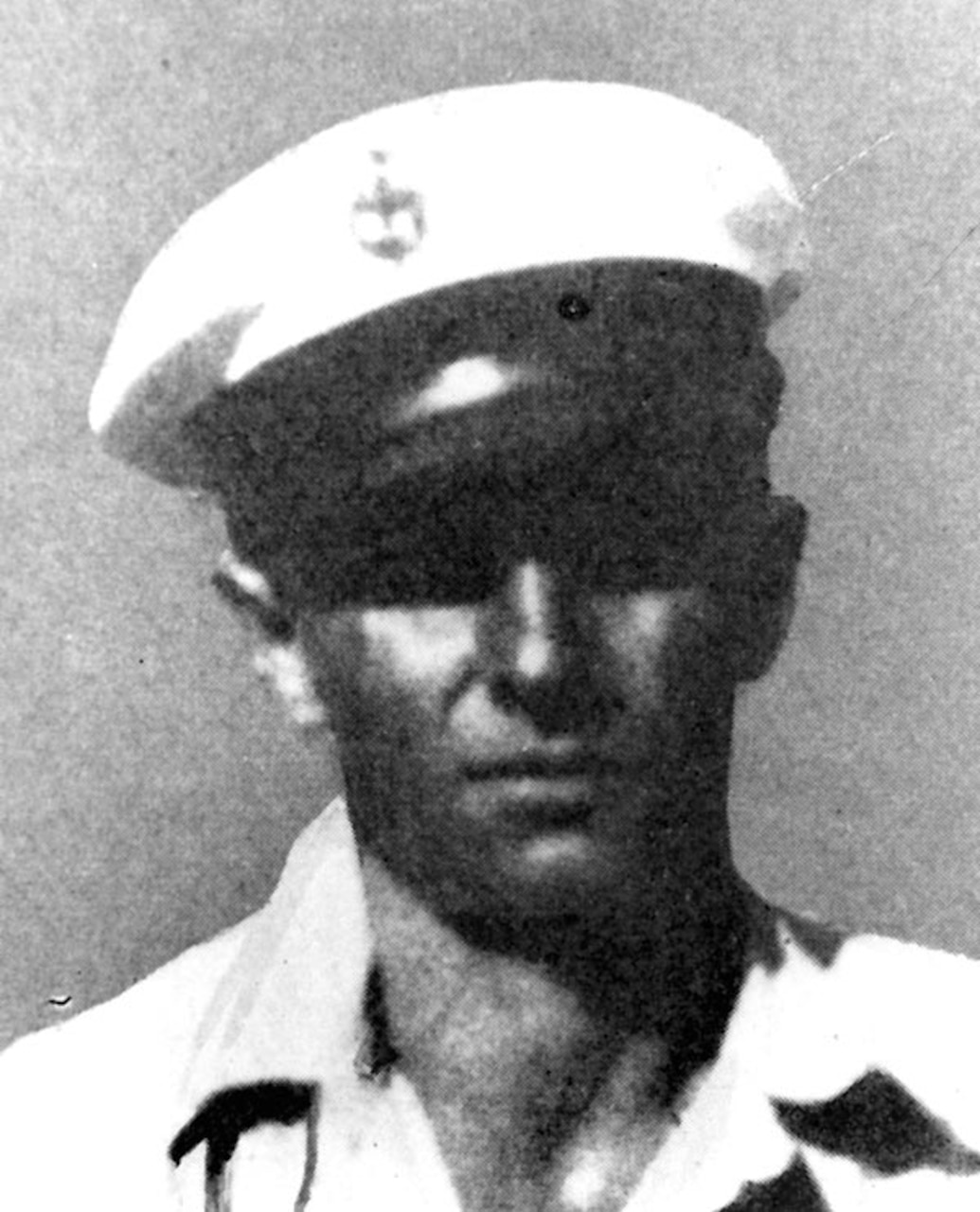 A  man in a Navy uniform poses for a photo.