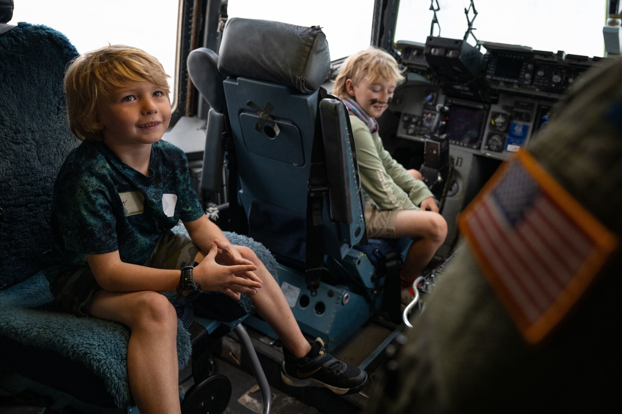 Service members’ children sit in a flight deck on a C-17 Globemaster III aircraft during a Kids Understanding Deployment Operations event at Joint Base McGuire-Dix-Lakehurst, N.J., Sept. 28, 2024. The KUDOS concept creates a simulated deployment line for service members’ children to process through in order to gain insight on the tasks their parents complete prior to deploying. (U.S. Air Force photo by Staff Sgt. Monica Roybal)