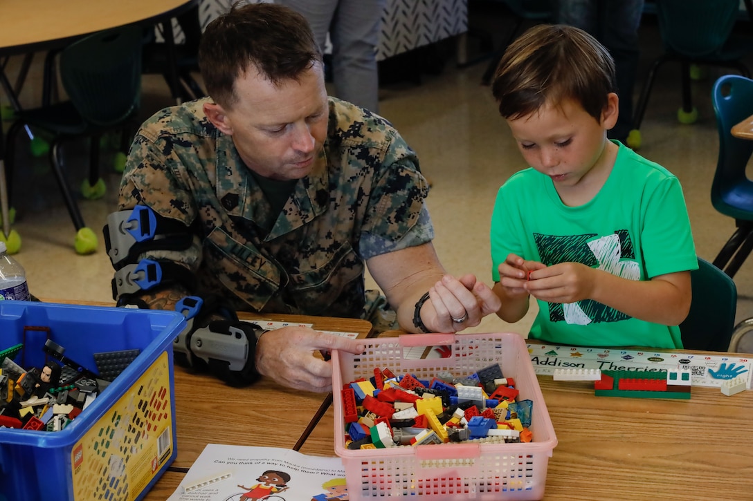 U.S. Marine Corps Gunnery Sgt. Steven Lilley, a kennel master with Marine Corps Base Hawaii Provost Marshalls Office, participates in an empathy exercise with his child during the school’s annual Science, Technology, Engineering, and Mathematics night, MCBH, Oct. 2 2024. School faculty, staff, families, and community experts participated in the event to support quality educational experiences for military children. (U.S. Marine Corps photo by Lance Cpl. Taylor Von Sanders-Frazer)