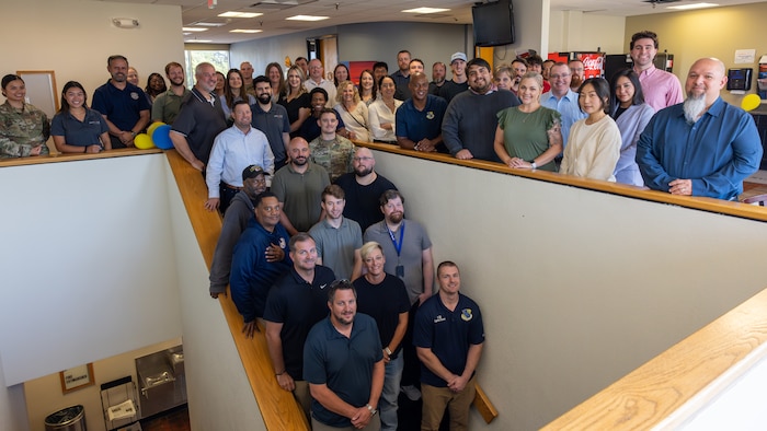 Large group of people standing around staircase for group photo