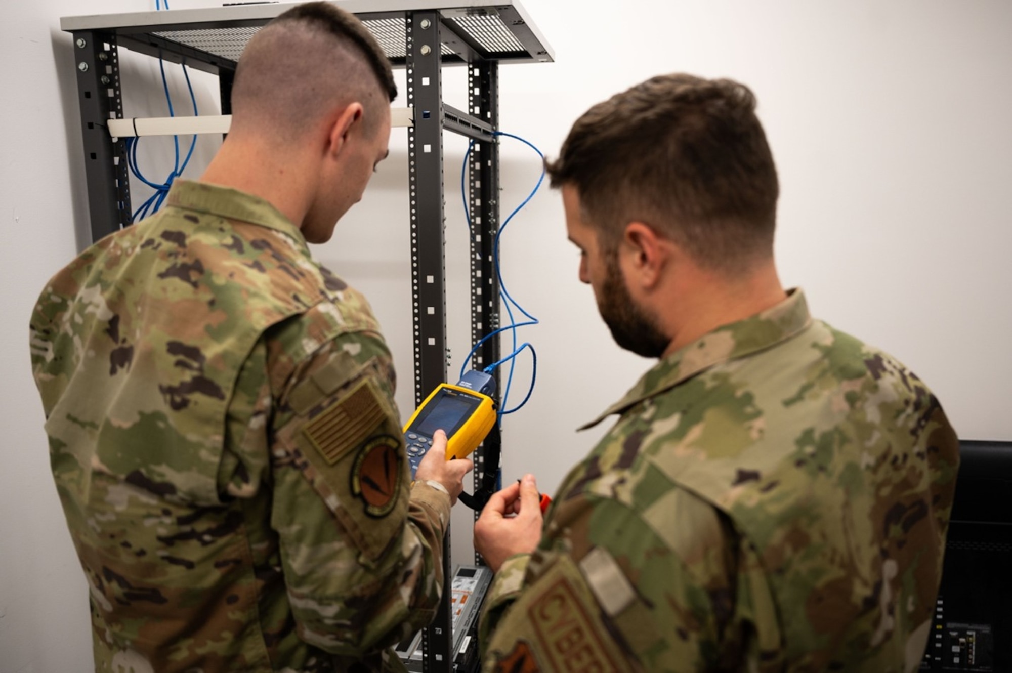 Airman 1st Class Terrance Butler, 633d Communications Squadron client systems technician, left, and Tech. Sgt. William Lamastro, 633d CS cable & antenna maintenance, right, test the connection of cables at Joint Base Langley-Eustis, Virginia, Sept. 11, 2024. Butler was successfully able to set up a network connection and learned how to connect cables in an office thanks to the guidance of Lamastro. (U.S. Air Force Photo by Airman Donnell Ramsey)