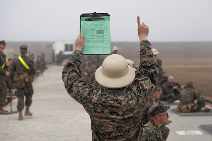 A U.S. Marine Corps primary marksmanship instructor with Weapons and Field Training Battalion, Recruit Training Regiment, holds up a range qualification card during a table one course of fire at Marine Corps Base Camp Pendleton, California, Oct. 3, 2024. The table one course of fire is designed to introduce recruits to the basic fundamentals of marksmanship and rifle safety. (U.S. Marine Corps photo by Cpl. Elliott A. Flood-Johnson)