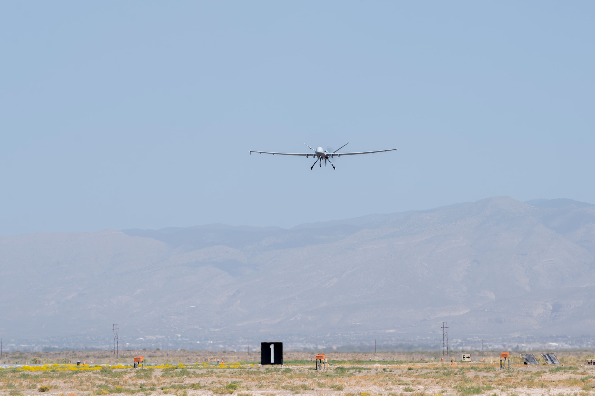 An MQ-9 Reaper assigned to the 49th Operations Group performs a low fly above a runway with Expeditionary Airfield Lighting Systems setup during Operation TRAILBLAZER at Holloman Air Force Base, New Mexico, Oct. 1, 2024.