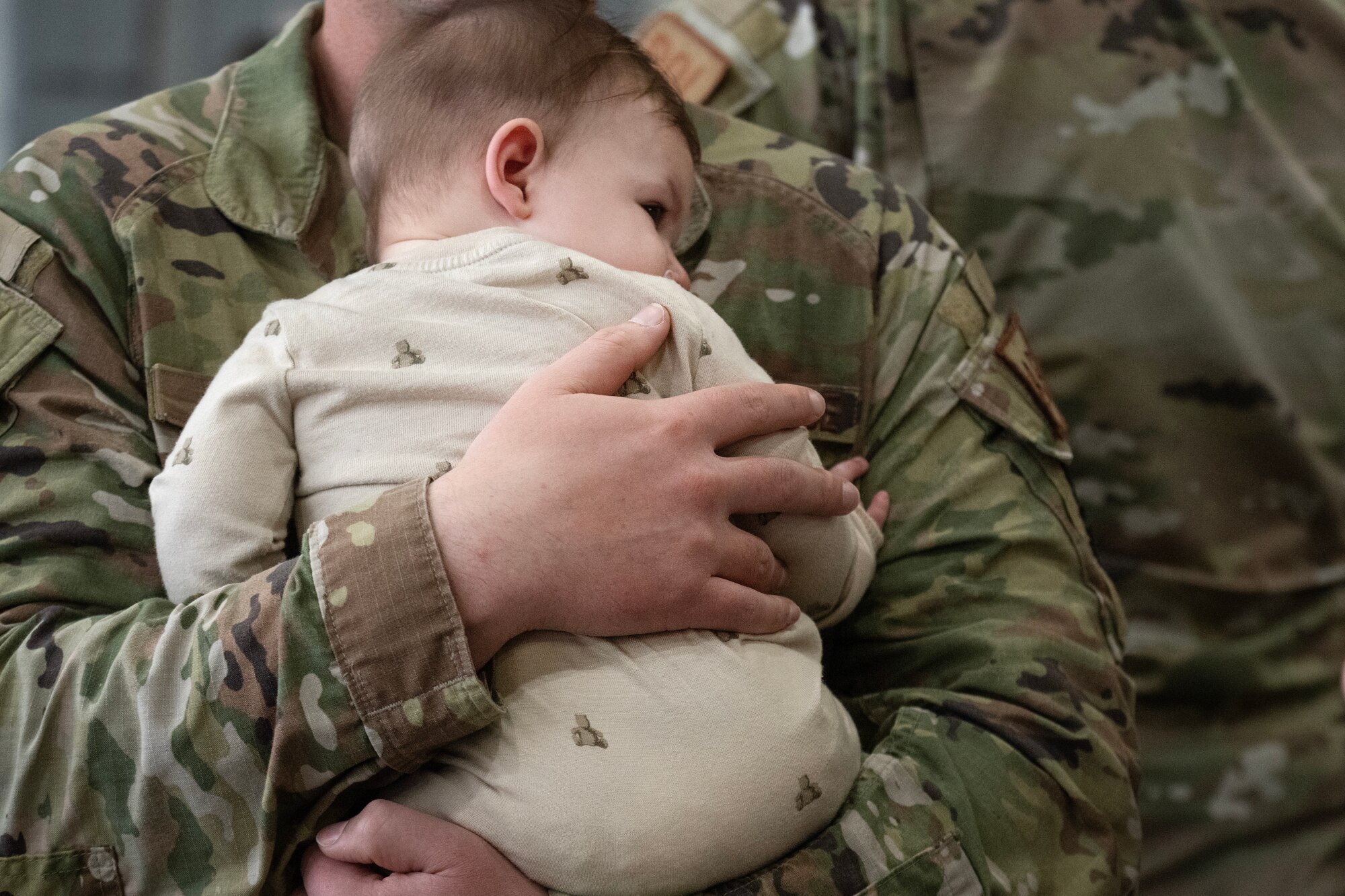 A U.S. Air Force Airman assigned to the 4th Communications Squadron holds his son after returning from a deployment.