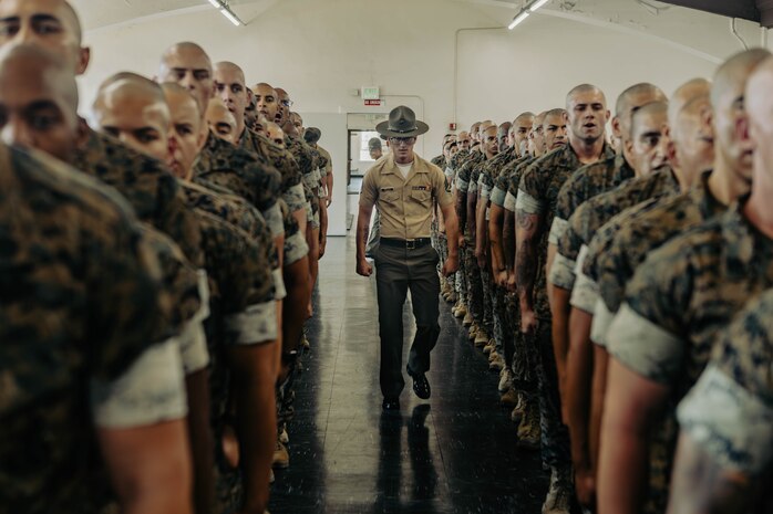 U.S. Marine Corps Staff Sgt. Thomas Brucia, an instructor with Marine Corps Recruit Depot San Diego Drill Instructor School, Recruit Training Regiment, observes the new Marines of DI school class 1-25 at Marine Corps Recruit Depot San Diego, California, Oct. 3, 2024. DI school develops leadership, command presence, instructional ability, physical fitness, and professional knowledge in officers and noncommissioned officers to prepare them for the duties of a drill instructor.  (U.S. Marine Corps photo by Sgt. Jesse K. Carter-Powell)