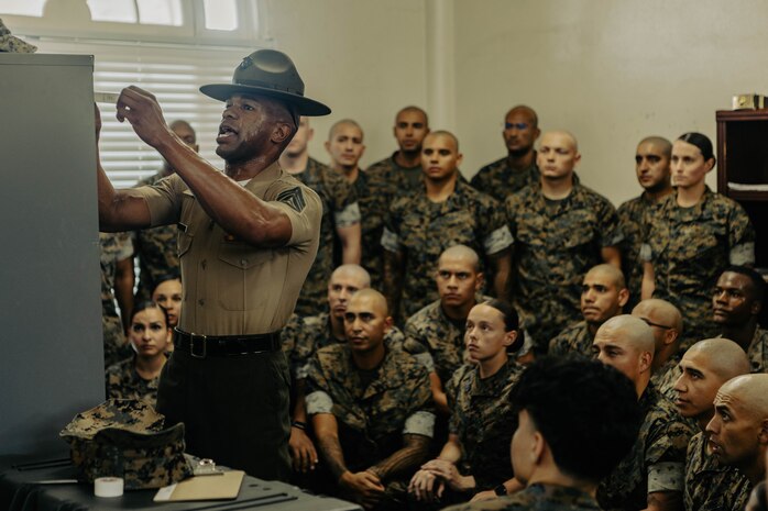 U.S. Marine Corps Staff Sgt. Klayton Inmon, an instructor with Marine Corps Recruit Depot San Diego Drill Instructor School, Recruit Training Regiment, instructs the new Marines of DI school class 1-25 on properly labeling a wall-locker at Marine Corps Recruit Depot San Diego, California, Oct. 3, 2024. DI school develops leadership, command presence, instructional ability, physical fitness, and professional knowledge in officers and noncommissioned officers to prepare them for the duties of a drill instructor.  (U.S. Marine Corps photo by Sgt. Jesse K. Carter-Powell)