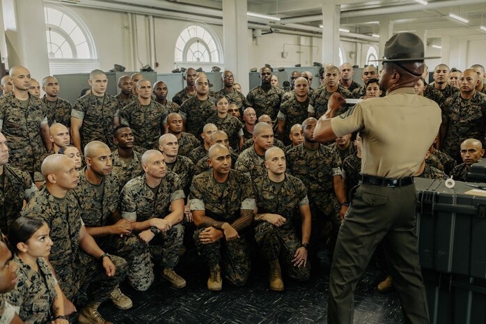 U.S. Marine Corps Staff Sgt. Klayton Inmon, an instructor with Marine Corps Recruit Depot San Diego Drill Instructor School, Recruit Training Regiment, instructs the new Marines of DI school class 1-25 on properly labeling a footlocker at Marine Corps Recruit Depot San Diego, California, Oct. 3, 2024. DI school develops leadership, command presence, instructional ability, physical fitness, and professional knowledge in officers and noncommissioned officers to prepare them for the duties of a drill instructor.  (U.S. Marine Corps photo by Sgt. Jesse K. Carter-Powell)