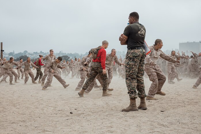 U.S. Marine Corps Martial Arts Instructor, Sgt. Thierno Jalloh, with Support Battalion, Recruit Training Regiment, leads warmup exercises for recruits with Alpha Company, 1st Recruit Training Battalion, before their Marine Corps Martial Arts Program class focusing on bayonet techniques at Marine Corps Recruit Depot San Diego, California, Sept. 30, 2024. MCMAP strengthens the mental and moral resiliency of individual recruits and Marines through realistic combative training, warrior ethos studies, and physical hardening. (U.S. Marine Corps photo by Cpl. Sarah M. Grawcock)
