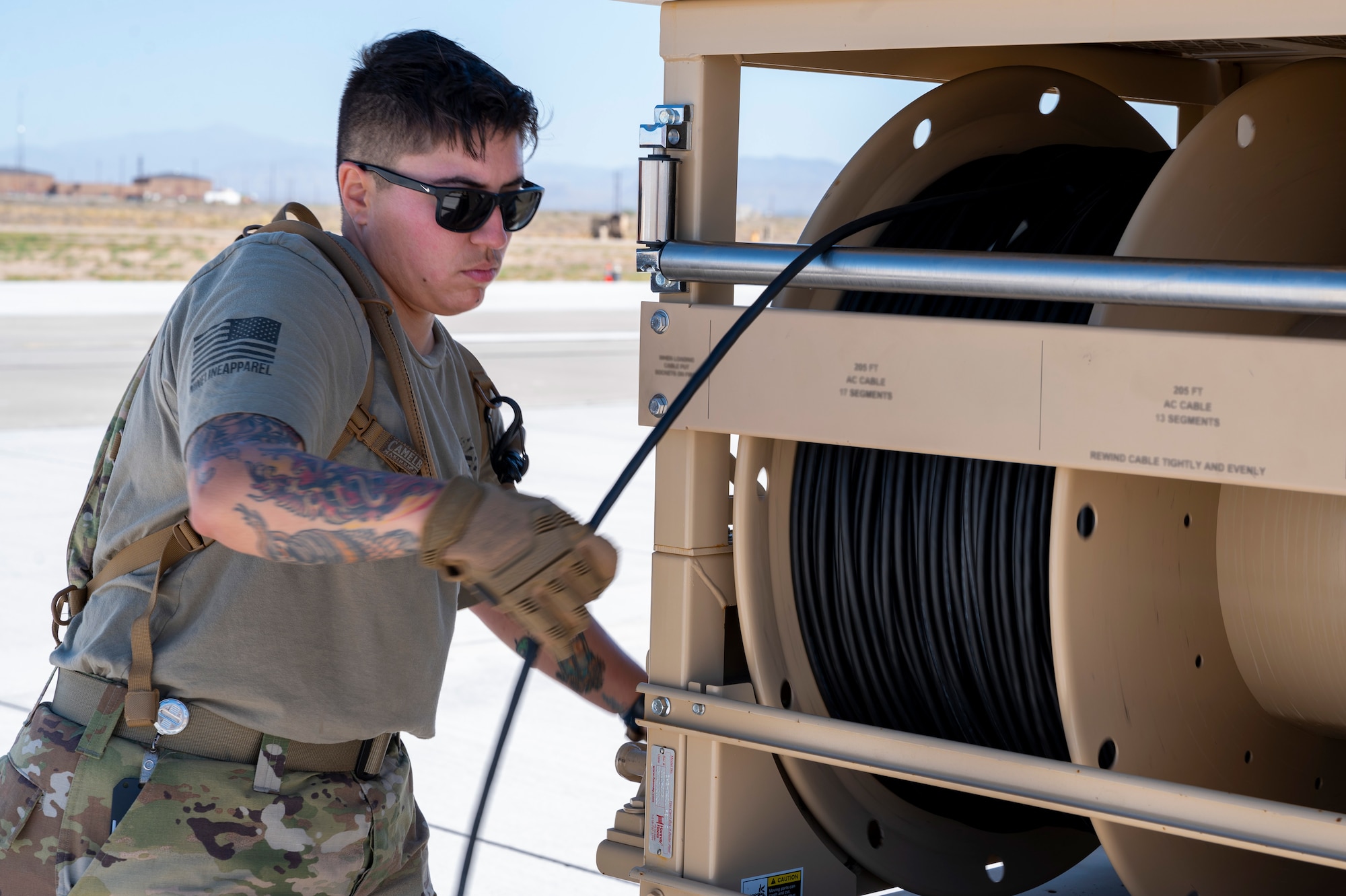 U.S. Air Force Tech. Sgt. Brianna Gonzales, 635th Materiel Maintenance Squadron regional training noncommissioned officer in charge, unravels a cord to power Expeditionary Airfield Lighting Systems-C during Operation TRAILBLAZER at Holloman Air Force Base, New Mexico, Oct. 1, 2024.