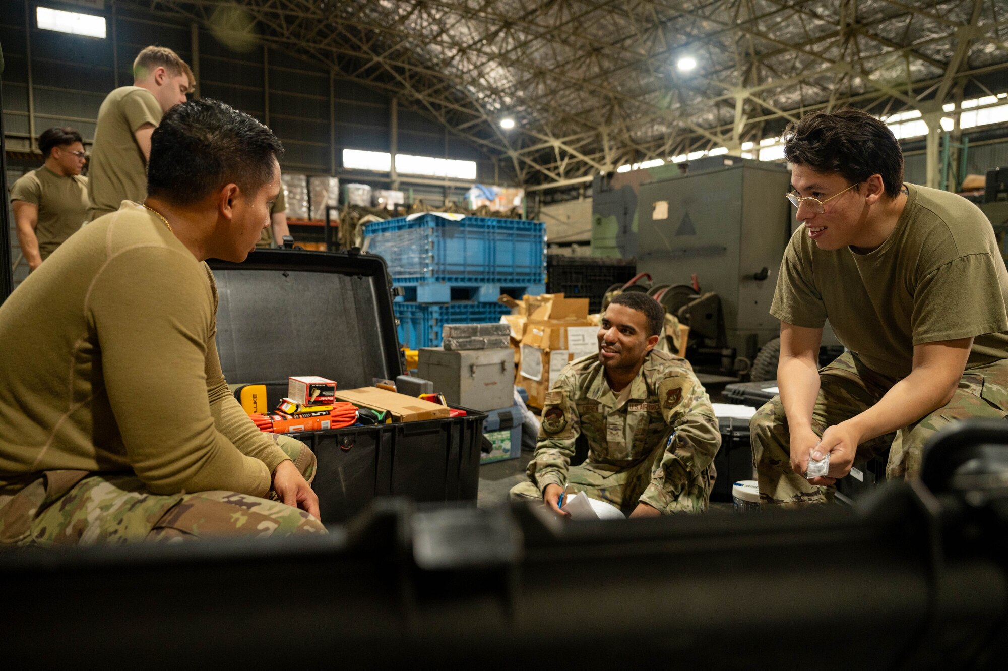 Three Airmen sort through tools.
