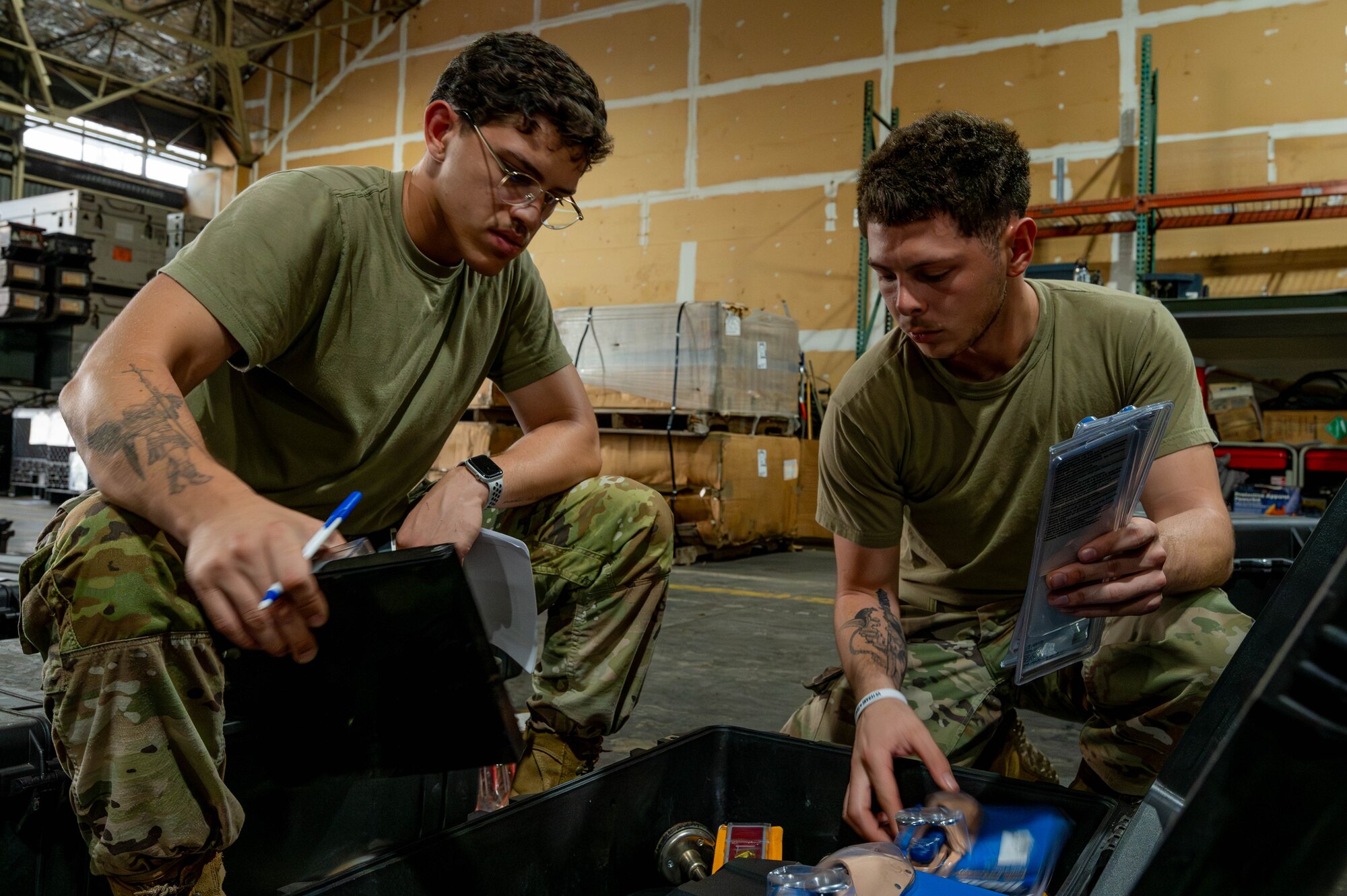 Two Airmen sort through tools.