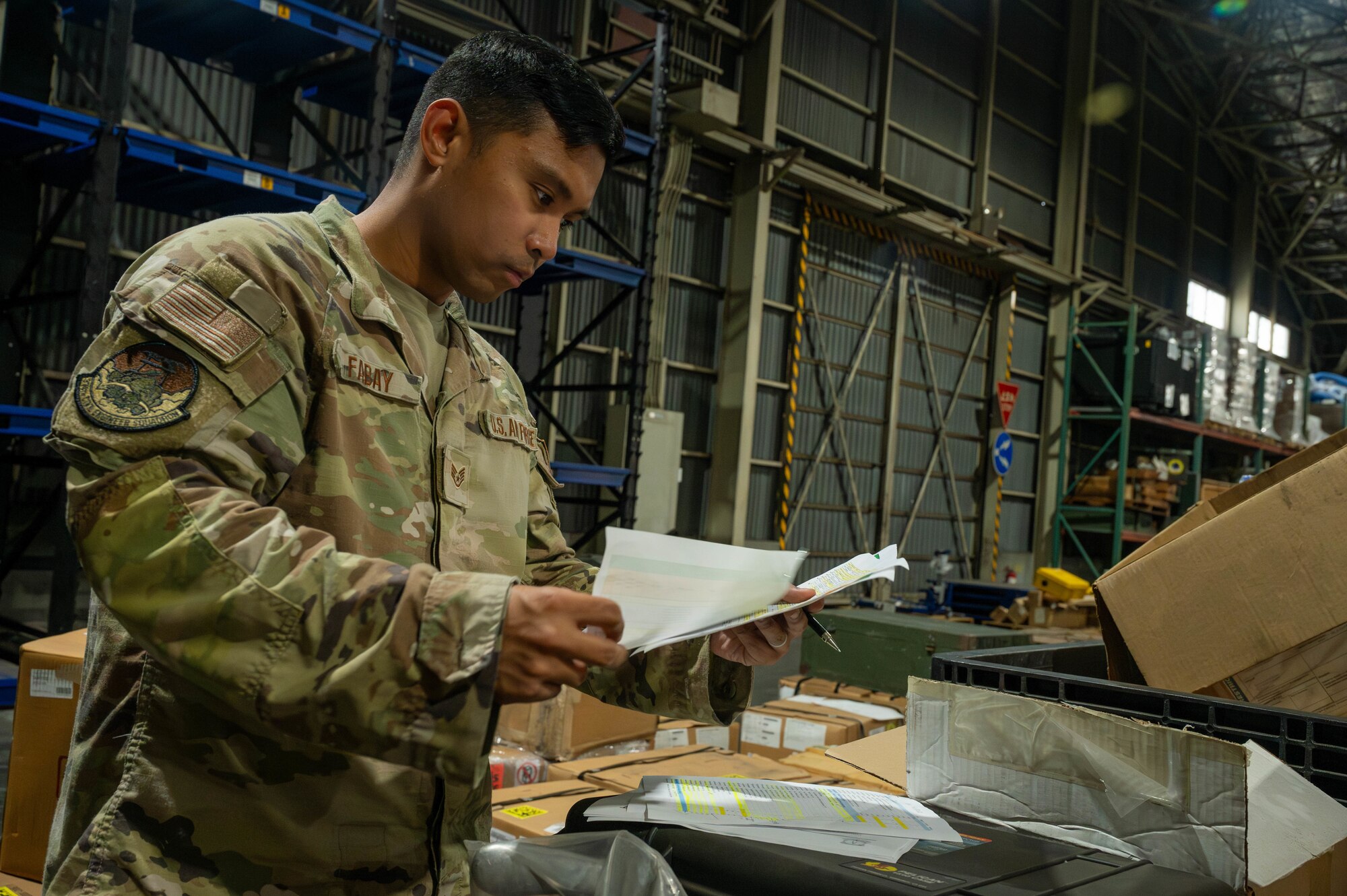 Airman looks at papers with list of items.