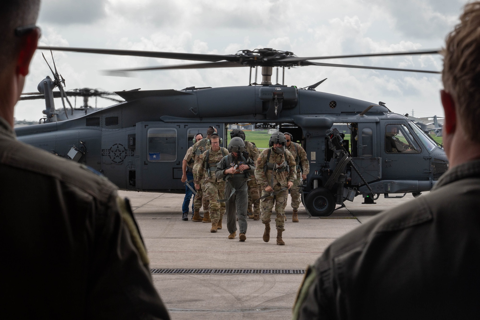 18th Wing and 5th AF leadership walking towards a hangar