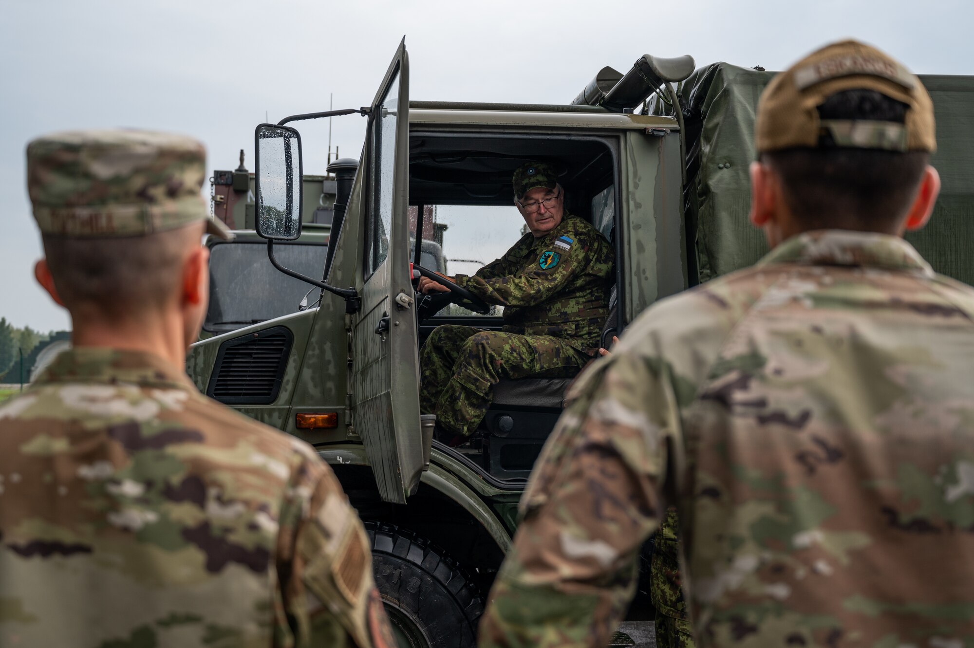 U.S. Air Force Master Sgt. Brady Tuthill, left, 175th Logistics Readiness Squadron ground transportation superintendent, and U.S. Air Force Staff Sgt. Luke Eskaros, right, 175th Logistics Readiness Squadron ground transportation craftsman, observe an Estonian Defense League counterpart during vehicle pre-inspections for Operation Baltic Rhino, September 14, 2024, at the Eametsa military base, Parnu, Estonia.