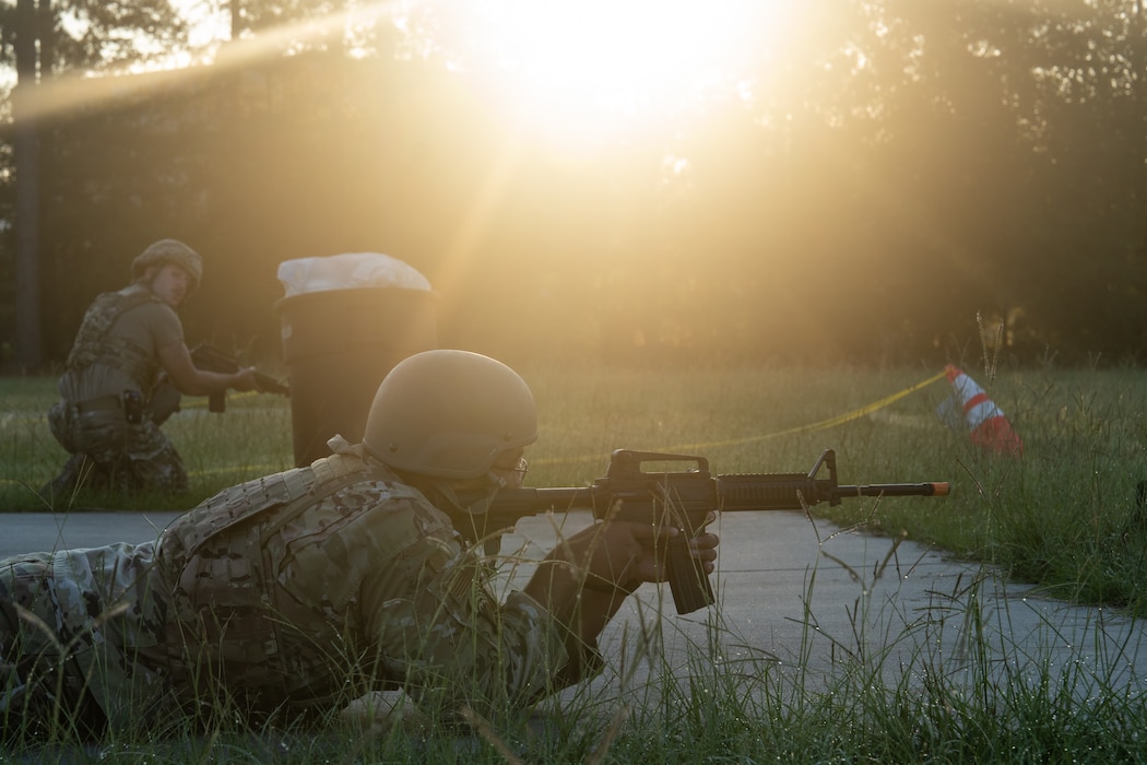 Two airmen aim rifles while defending an area