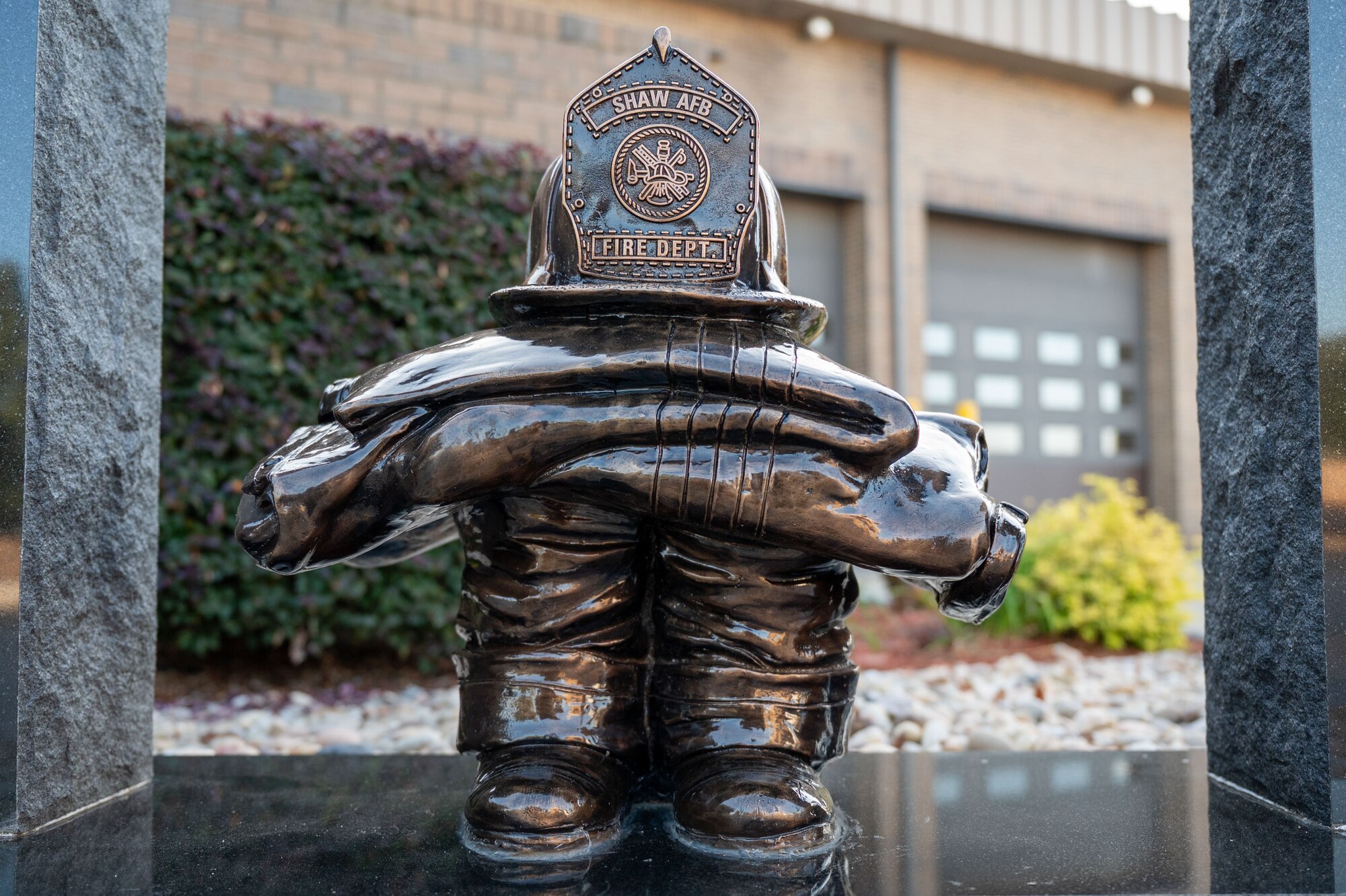 A sculpture of a fire jacket and helmet resting on a pair of boots.