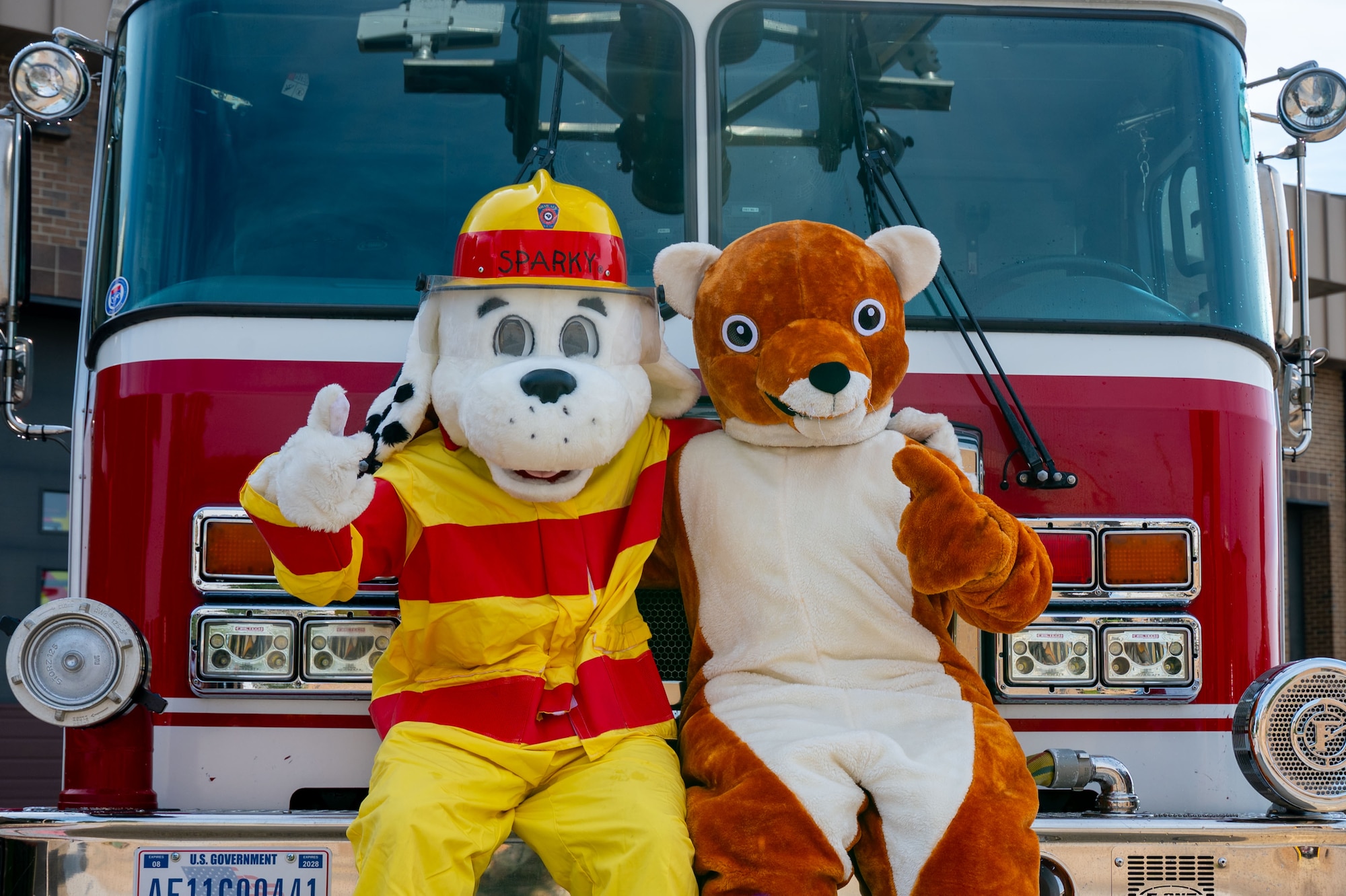 Sparky the Fire Dog and the 20th Fighter Wing Weasel mascot pose for a photo.