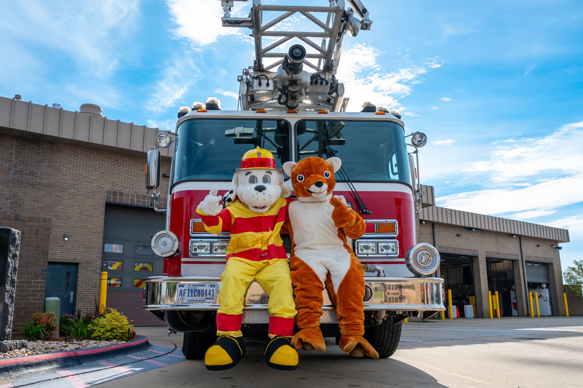 Sparky the Fire Dog and the 20th Fighter Wing Weasel mascot pose for a photo.