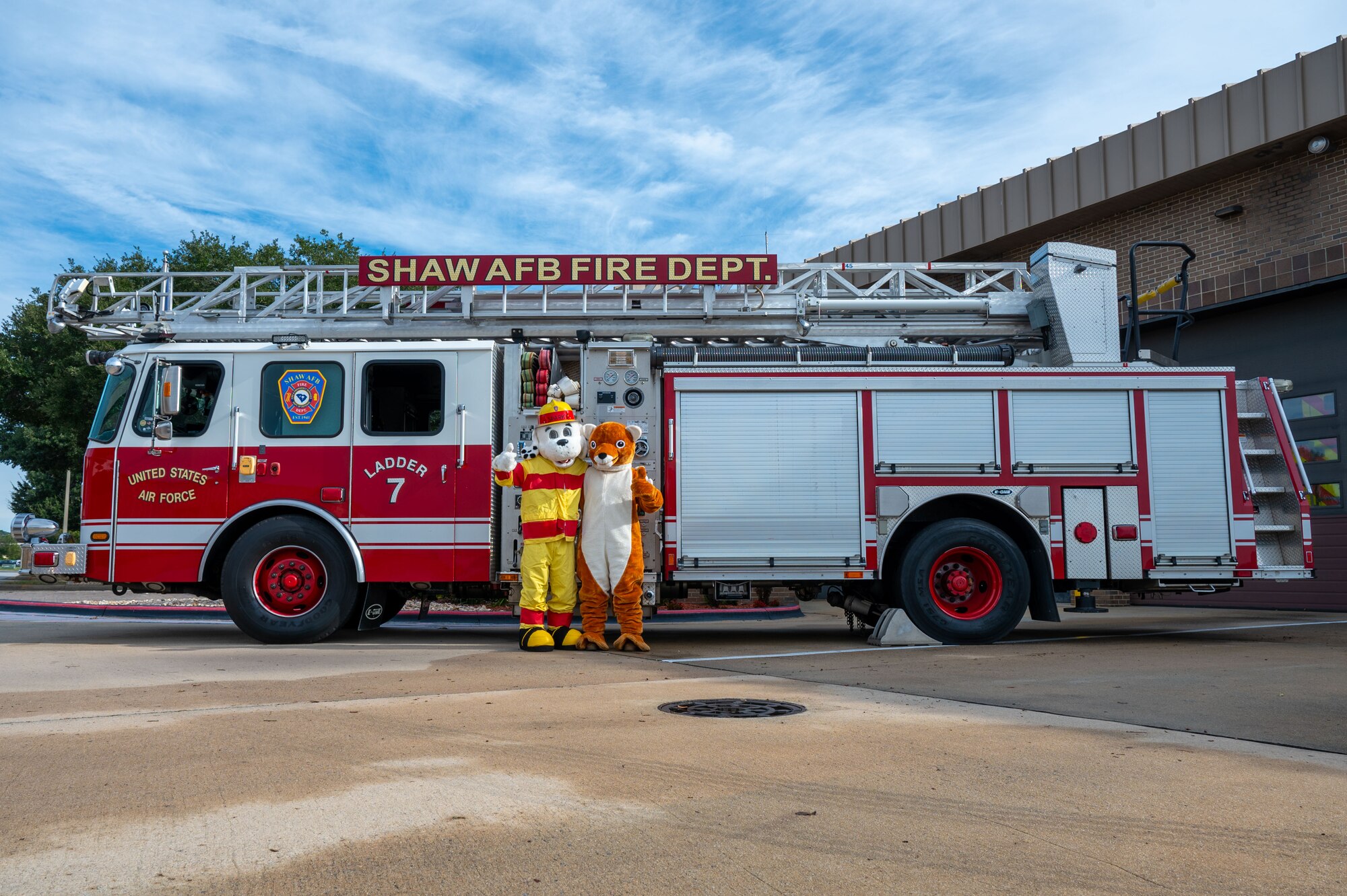 Sparky the Fire Dog and the 20th Fighter Wing Weasel mascot pose for a photo.