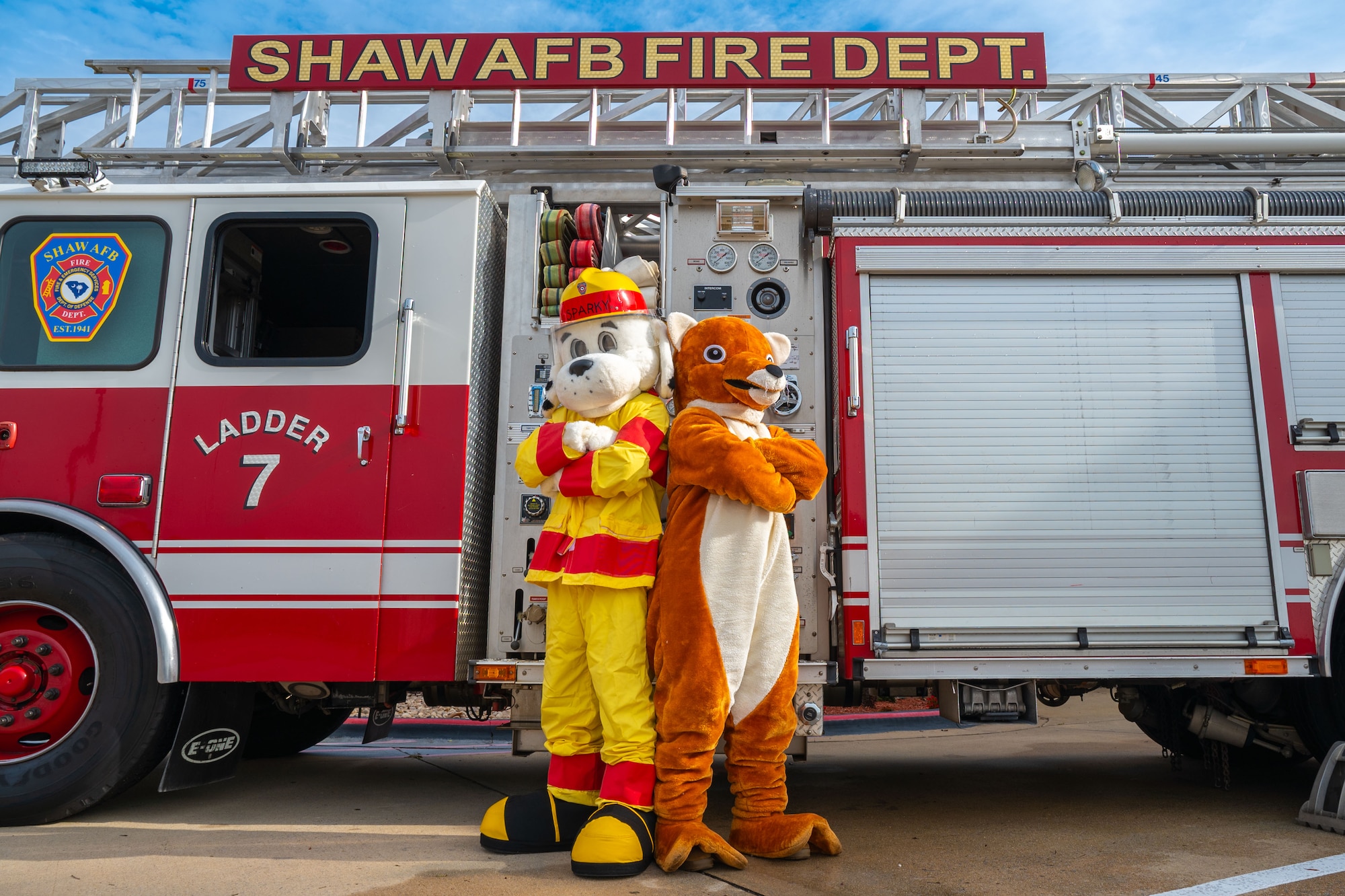 Sparky the Fire Dog and the 20th Fighter Wing Weasel mascot pose for a photo.