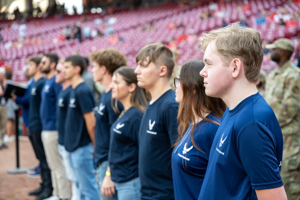 Group of men and women in blue standing in a line.