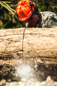 U.S. Air National Guard Tech. Sgt. Ryan Schulze, 118th Wing pavements and construction equipment craftsman, cuts a fallen tree with a chainsaw during Hurricane Helene relief efforts in Elizabethton, Tennessee, Oct. 5, 2024. Airmen continue to commute to the town and surrounding areas daily to help clear debris and help local residents in need due to flooding from Hurricane Helene.