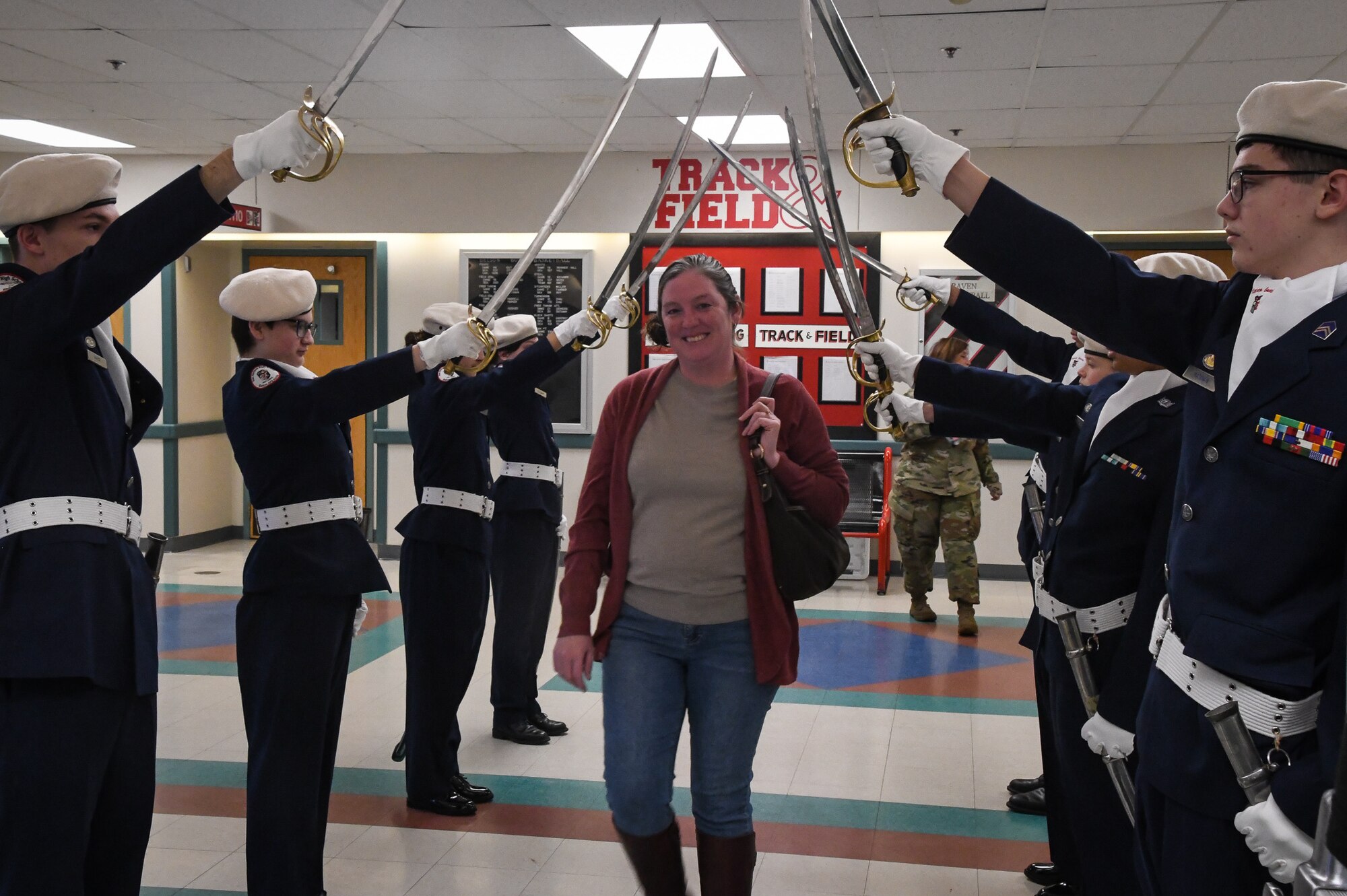 Master Sgt. (Ret.) Shelly Lutrell  walks through the archway presented by Ben Eielson High School Junior Reserve Officer Training Corps (JROTC) cadets to honor Veterans during the Ben Eielson HS Veterans Day Breakfast, Nov. 10, 2022.