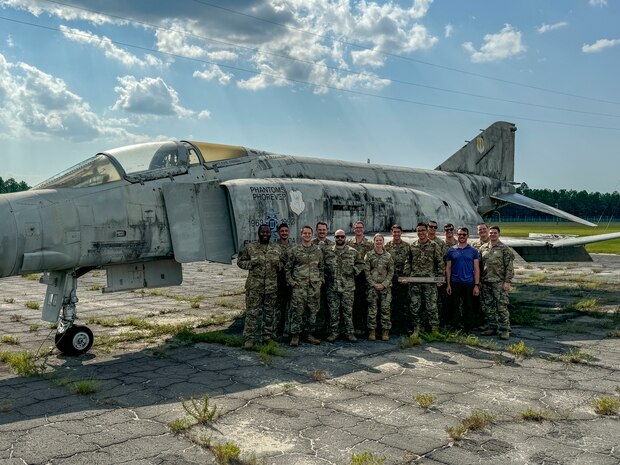 The Beale Air Force Base Combat Innovation Exercise Team poses for a photo next to a decommissioned McDonnell Douglas F-4 Phantom II at after successfully completing two week of Innovation training and Combat Innovation scenarios Eglin Air Force Base, Florida, Aug. 8, 2024.