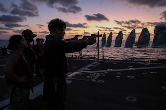 Sailors aboard USS Arleigh Burke (DDG 51) conduct a 9mm pistol qualification course in the Mediterranean Sea.