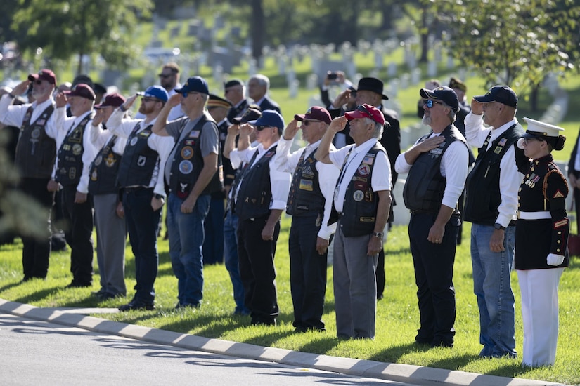 A row of people salute.