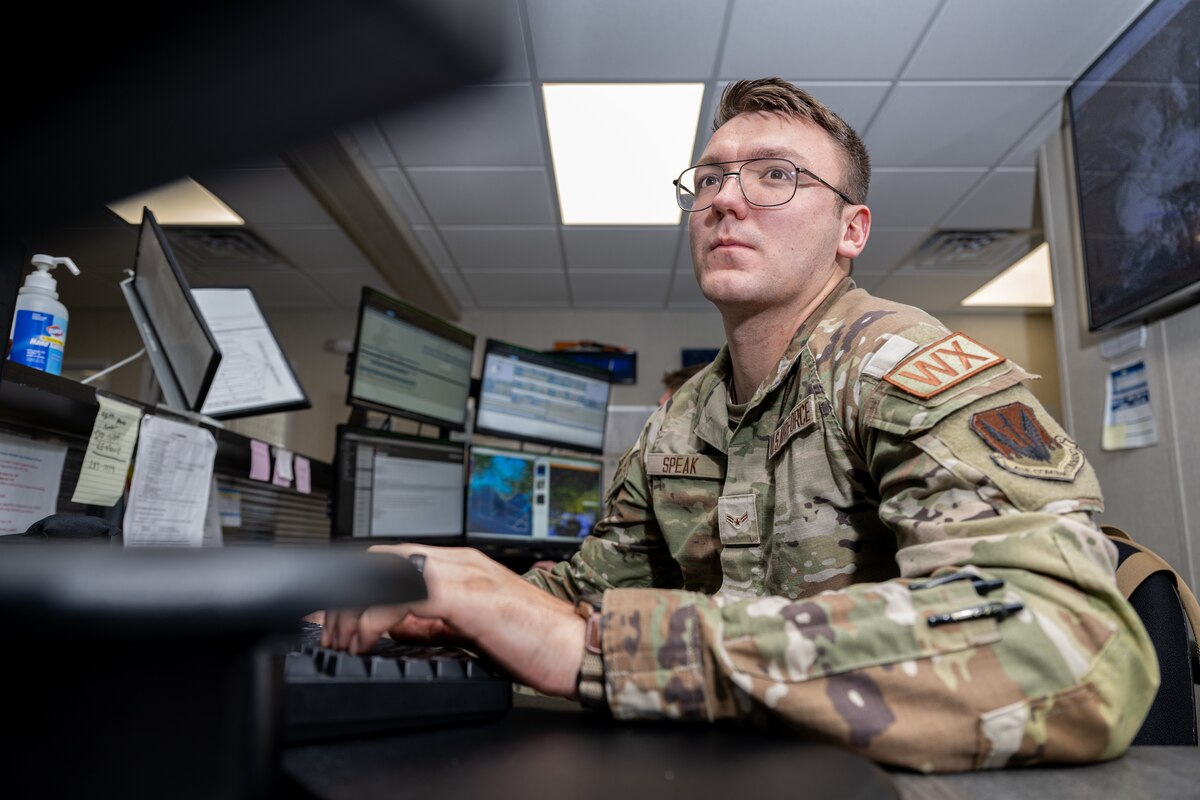 An Airman sits at a desk