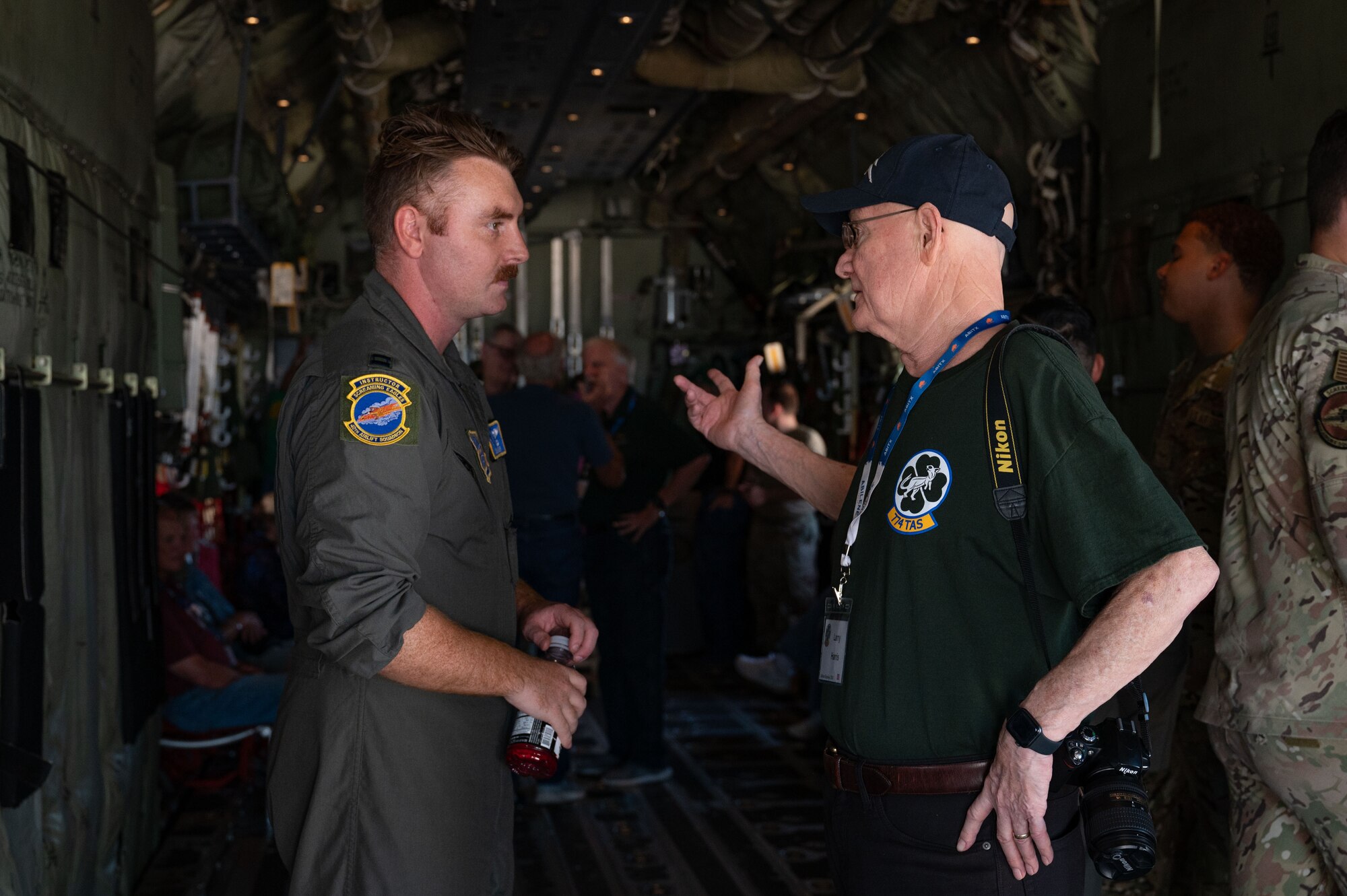 U.S. Air Force Capt. Sean Mishler, 40th Airlift Squadron pilot, speaks to a 774th Tactical Airlift Squadron veteran about technology upgrades on the C-130J Super Hercules at Dyess Air Force Base, Texas, Oct. 4, 2024. Over 100 veterans attended a 774th TAS reunion, touring base facilities and seeing the technological advances the 317th Airlift Wing has made. (U.S. Air Force Photo by Airman 1st Class Emma Anderson)