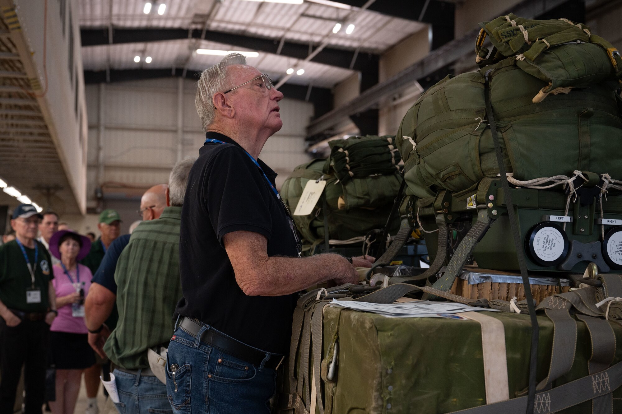 A 774th Tactical Airlift Squadron veteran looks at a variety of air drop bundles at Dyess Air Force Base, Texas, Oct. 7, 2024. Over 100 veterans attended a 774th TAS reunion, touring base facilities and seeing the technological advances the 317th Airlift Wing has made. (U.S. Air Force Photo by Airman 1st Class Emma Anderson)