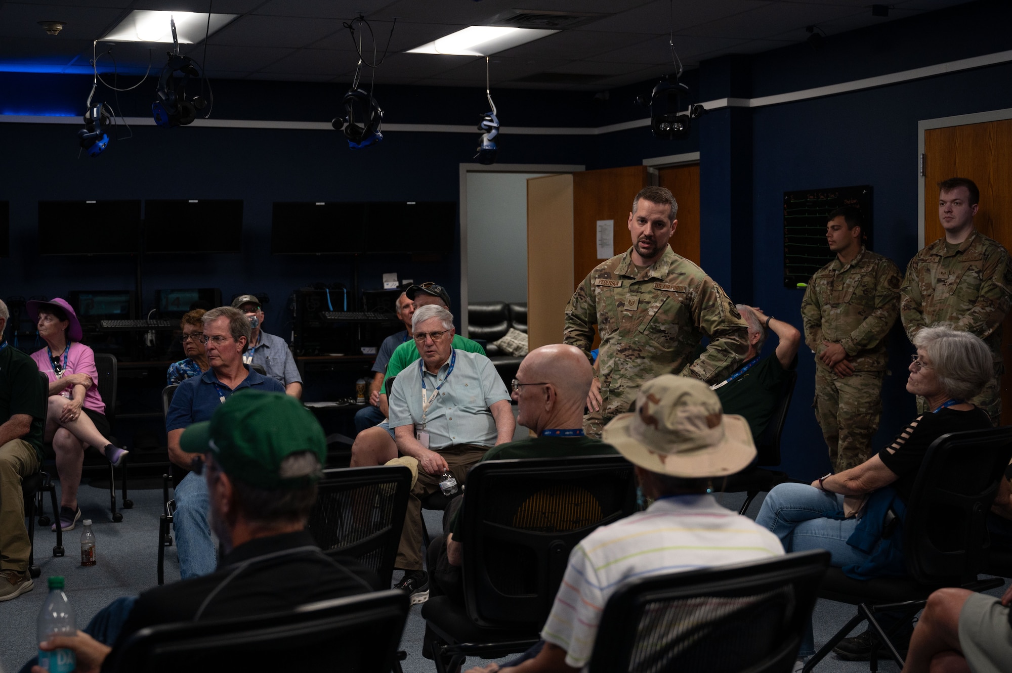 U.S. Air Force Tech. Sgt. David Pederson, 317th Maintenance Group extended reality section chief, speaks with 774th Tactical Airlift Squadron veterans at Dyess Air Force Base, Texas, Oct. 7, 2024.  The veterans were taught about the digital simulator prototype for the C-130J Super Hercules, which makes training for aircrew and maintainers more efficient by decreasing use of resources in a safe and controlled environment. (U.S. Air Force photo by Airman 1st Class Emma Anderson)