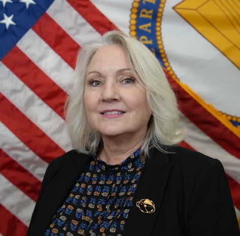 Stephanie Hall, Director of Regional Business in front of US and SES flags.
