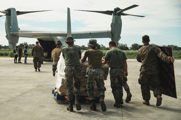 U.S. Marines assigned to the 15th Marine Expeditionary Unit and Philippine Marines assigned to 4th Marine Brigade load USAID supplies into an MV-22B Osprey during foreign disaster relief operations at the Laoag International Airport in Laoag City, llocos Norte, Philippines, Oct. 8, 2024.