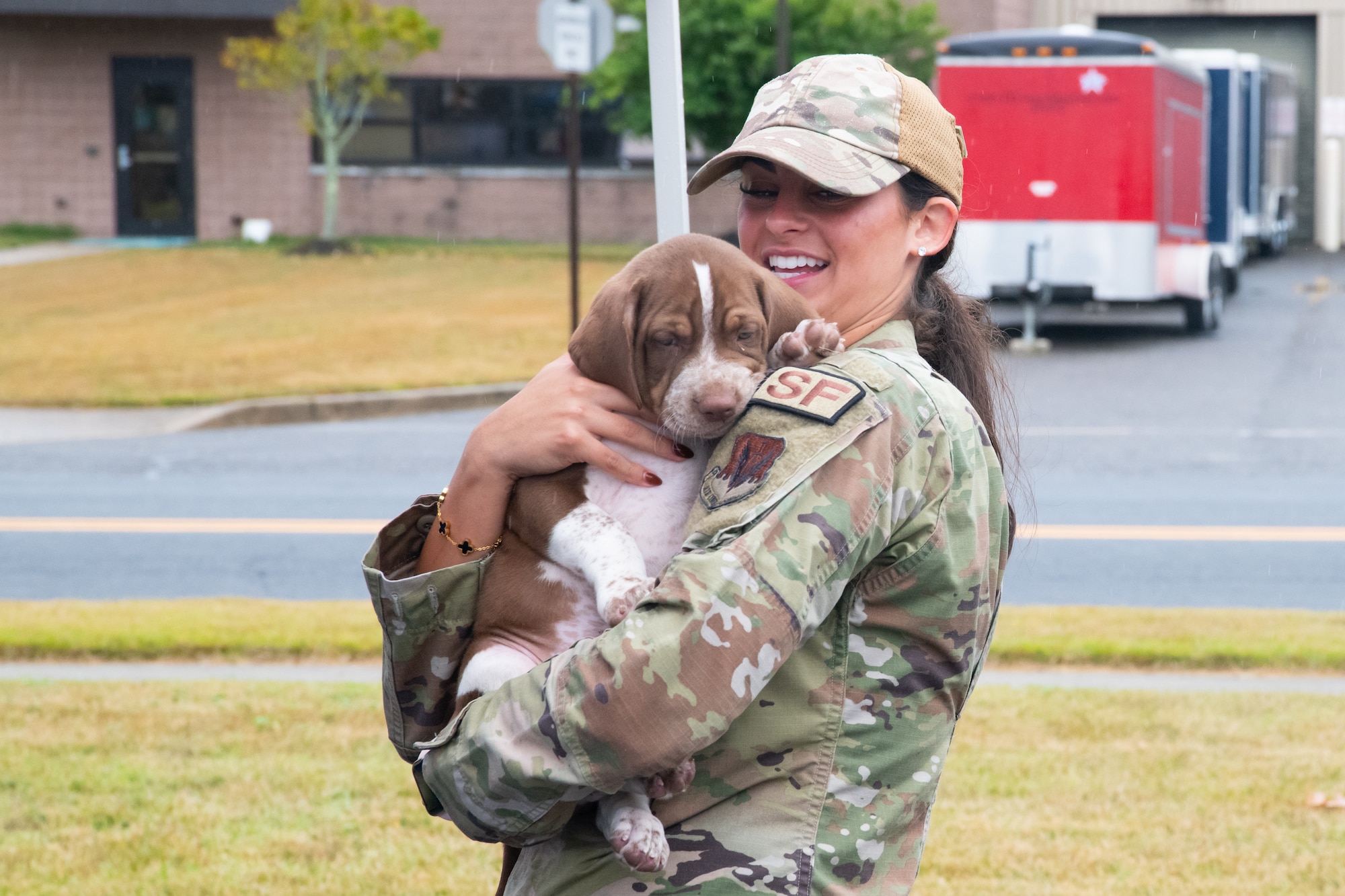 U.S. Air Force Senior Airman Angelina Pollino holds a puppy during Community Assessment and Resilience Engagement (CARE) day.