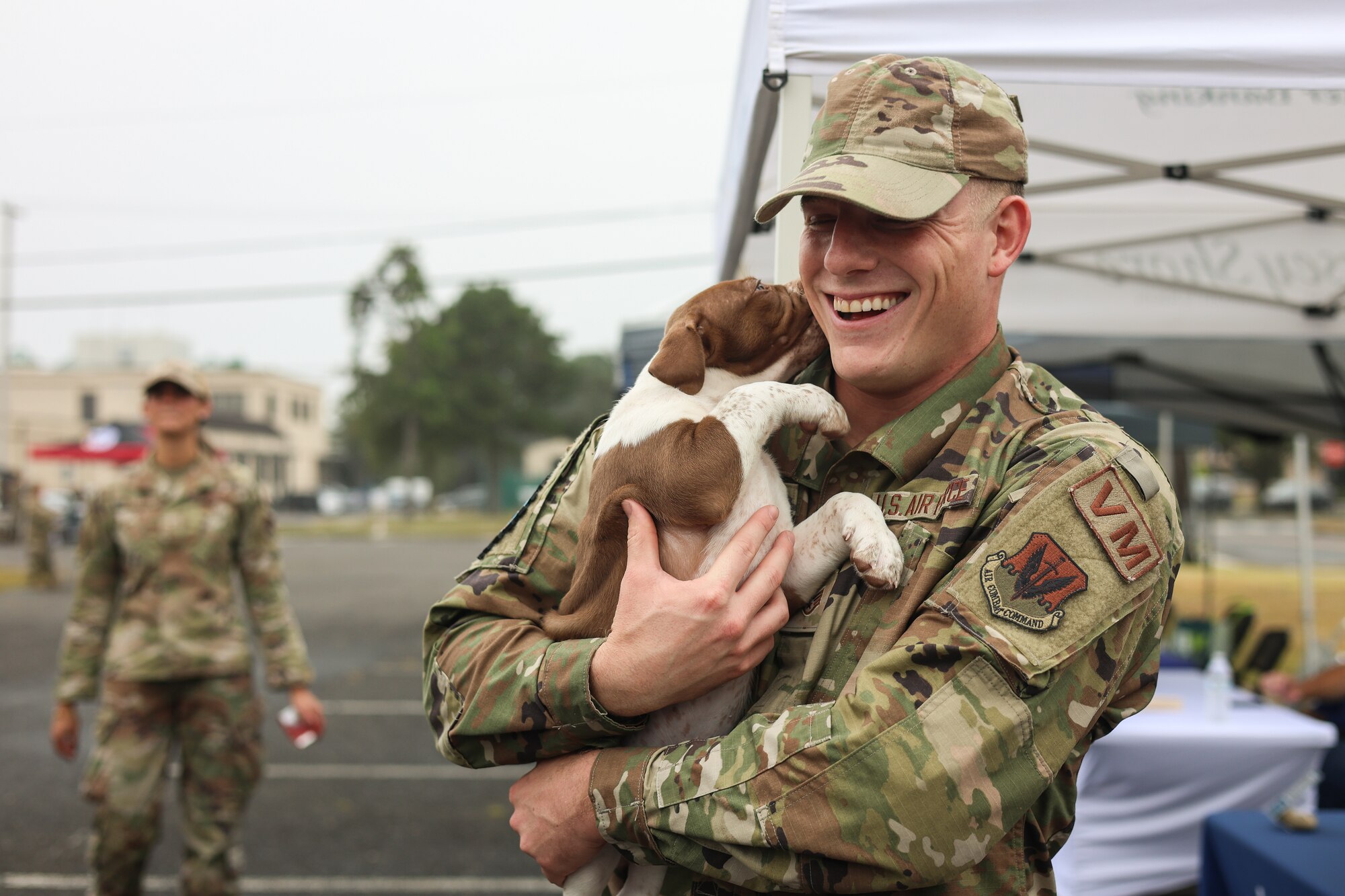 U.S. Air Force Staff Sgt. Kevin Vandever, 177th Vehicle Maintenance technician, holds a puppy during Community Assessment and Resilience Engagement (CARE) day at the 177th Fighter Wing, Egg Harbor Township, New Jersey, Sept. 27, 2024. CARE day is a program in which members of the 177th FW can come together to celebrate community and new partnerships. (U.S. Air National Guard photo by Airman 1st Class Connor Taggart)