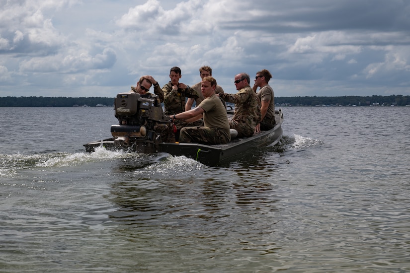 A group of soldiers on a motorized boat during a sunny day move on the water.