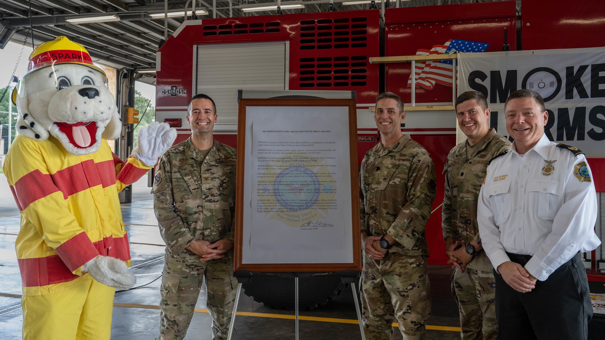U.S. Air Force Col. Morgan Lohse, 4th Fighter Wing commander, and members of the 4th Civil Engineer Squadron fire station pose for a photo after signing the 2024 Fire Prevention Proclamation at Seymour Johnson Air Force Base, North Carolina, Oct. 1, 2024. The theme for 2024 Fire Prevention Week stresses the importance of having a functional smoke alarm to increase the chance of survival during a house fire. (U.S. Air Force photo by Airman 1st Class Rebecca Tierney)