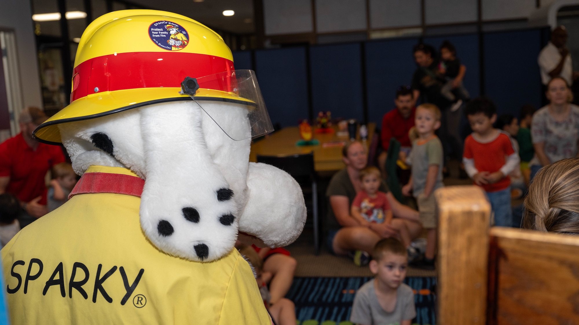 Sparky the dog, fire prevention mascot, greets children at the base library during 2024 Fire Prevention Week at Seymour Johnson Air Force Base, North Carolina, Oct. 7, 2024. The theme for 2024 Fire Prevention Week stresses the importance of having a functional smoke alarm to increase the chance of survival during a house fire. (U.S. Air Force photo by Airman 1st Class Rebecca Tierney)