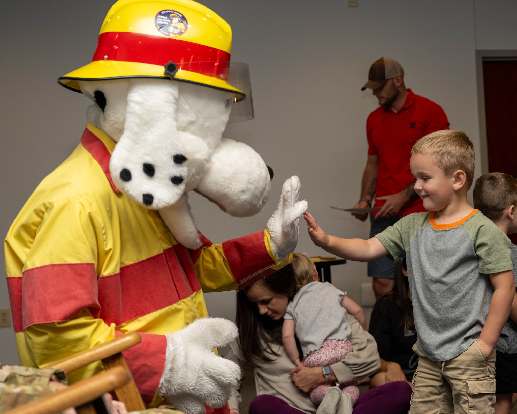 Sparky the dog, fire prevention mascot, greets children at the base library during 2024 Fire Prevention Week at Seymour Johnson Air Force Base, North Carolina, Oct. 7, 2024. The theme for 2024 Fire Prevention Week stresses the importance of having a functional smoke alarm to increase the chance of survival during a house fire. (U.S. Air Force photo by Airman 1st Class Rebecca Tierney)