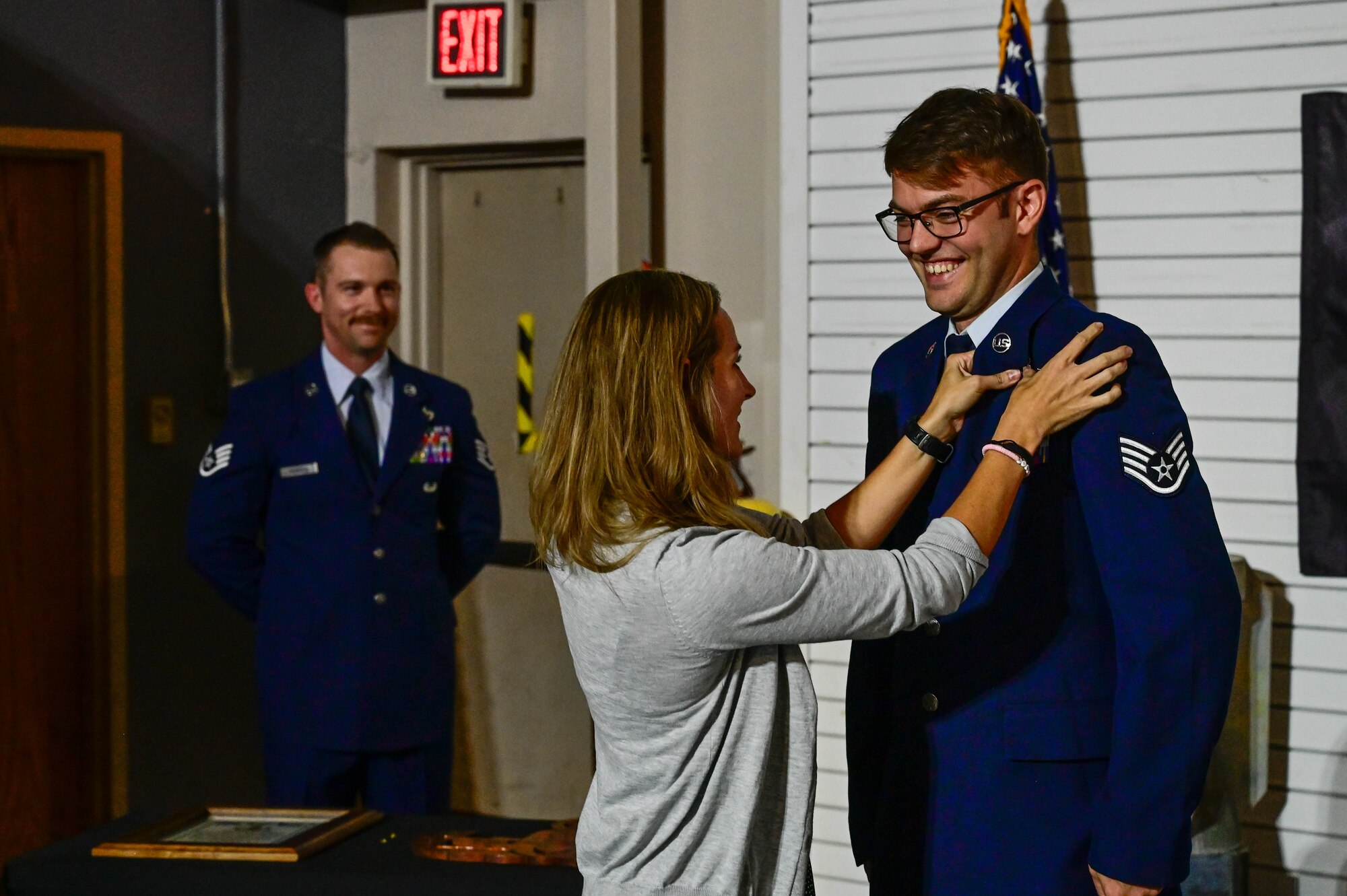 Wife pins badge on airman's uniform
