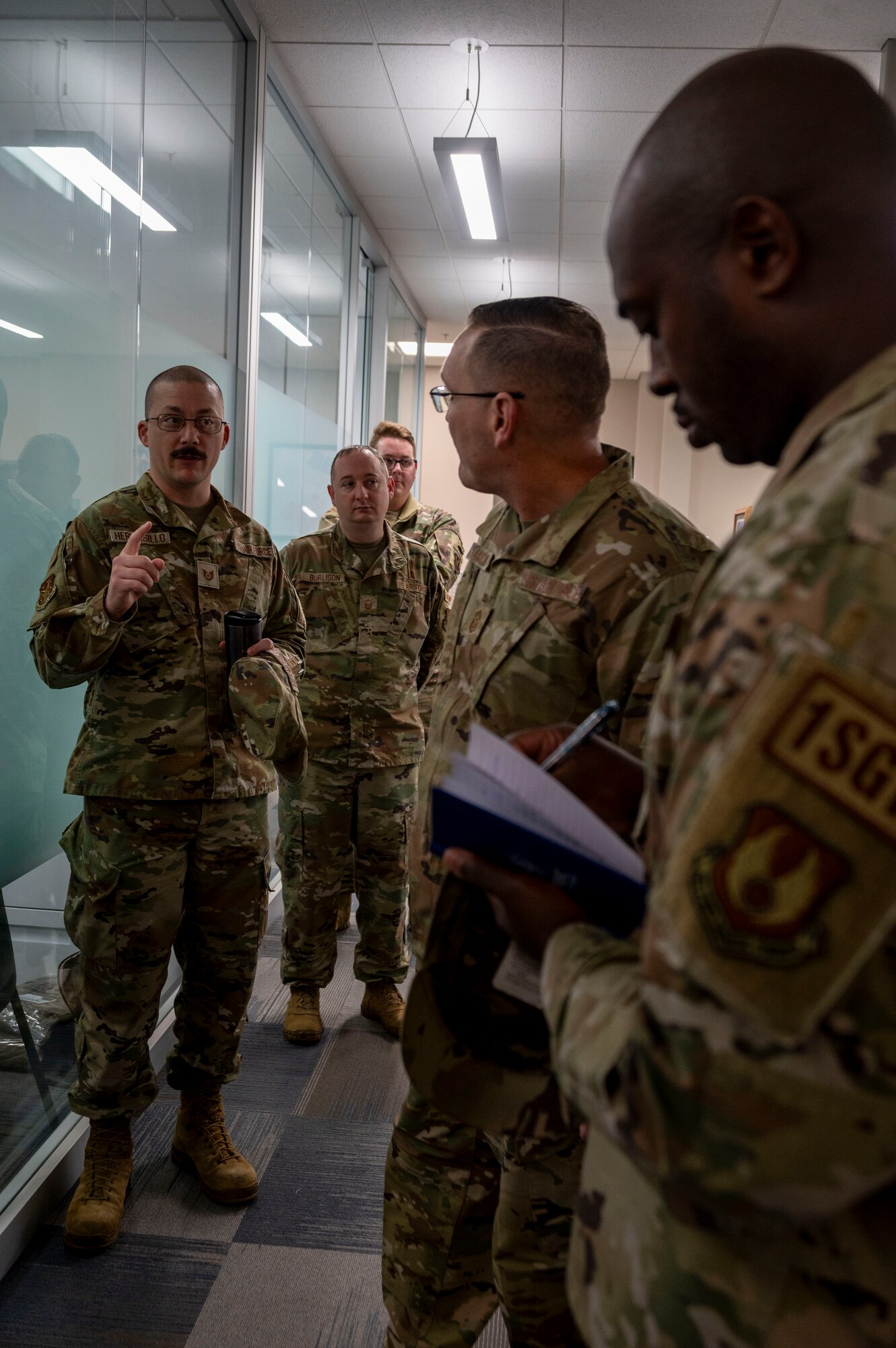 Chief Master Sgt. Travis Chadick, Air Force Nuclear Weapons Center command chief (center), listens to TSgt. Christopher Hermosillo, 91st Maintenance Group (91 MXG) non-commissioned officer in charge quality assurance programs (left), describes the challenges Airmen assigned to the 91 MXG face at Minot Air Force Base, North Dakota, Oct. 4, 2024. The visit provided an opportunity for Chadick to discuss readiness and the vital role of maintenance personnel in supporting the nuclear deterrence mission. (U.S. Air Force photo by Airman 1st Class Luis Gomez)